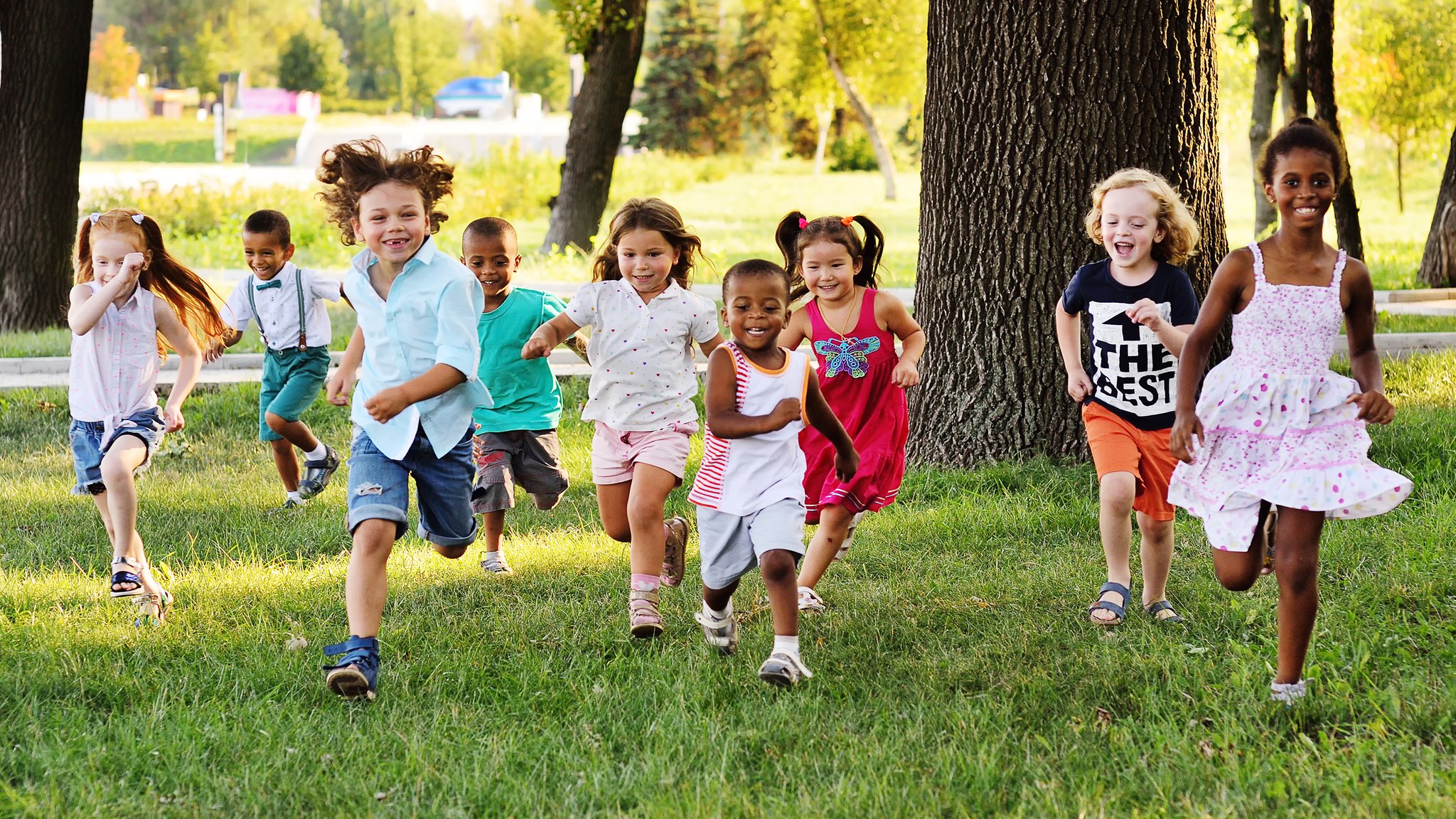 Spielende Kinder rennen durch einen Park. | Bild: stock.adobe.com/Evgeniy Kalinovskiy Spielende Kinder rennen durch einen Park.