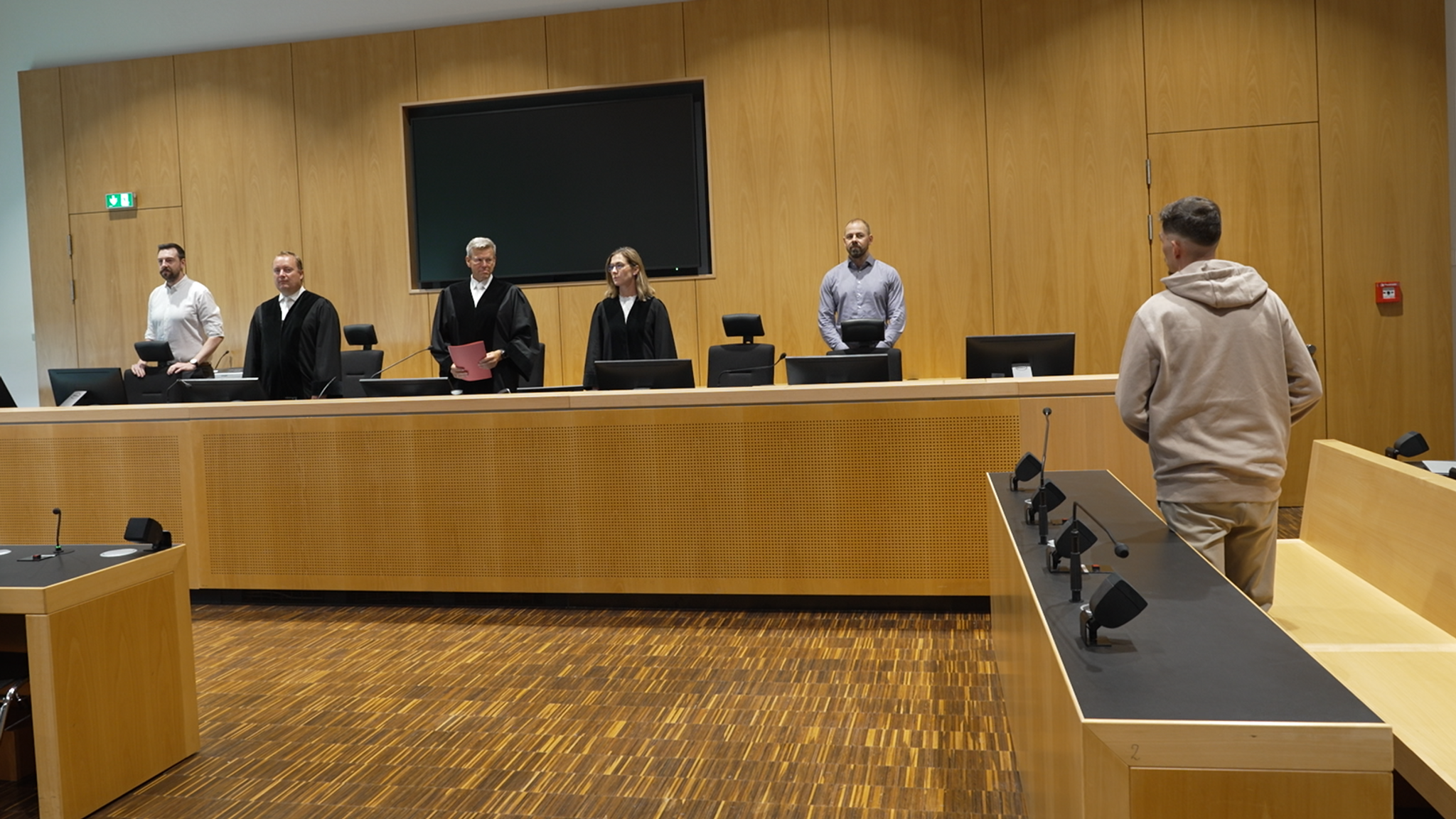 Gerichtssaal im Landgericht Augsburg. Angeklagter steht im beigen Kapuzenpulli vor den Richtern und Schöffen. | Bild: BR/Simon Frick Gerichtssaal im Landgericht Augsburg. Angeklagter steht im beigen Kapuzenpulli vor den Richtern und Schöffen.