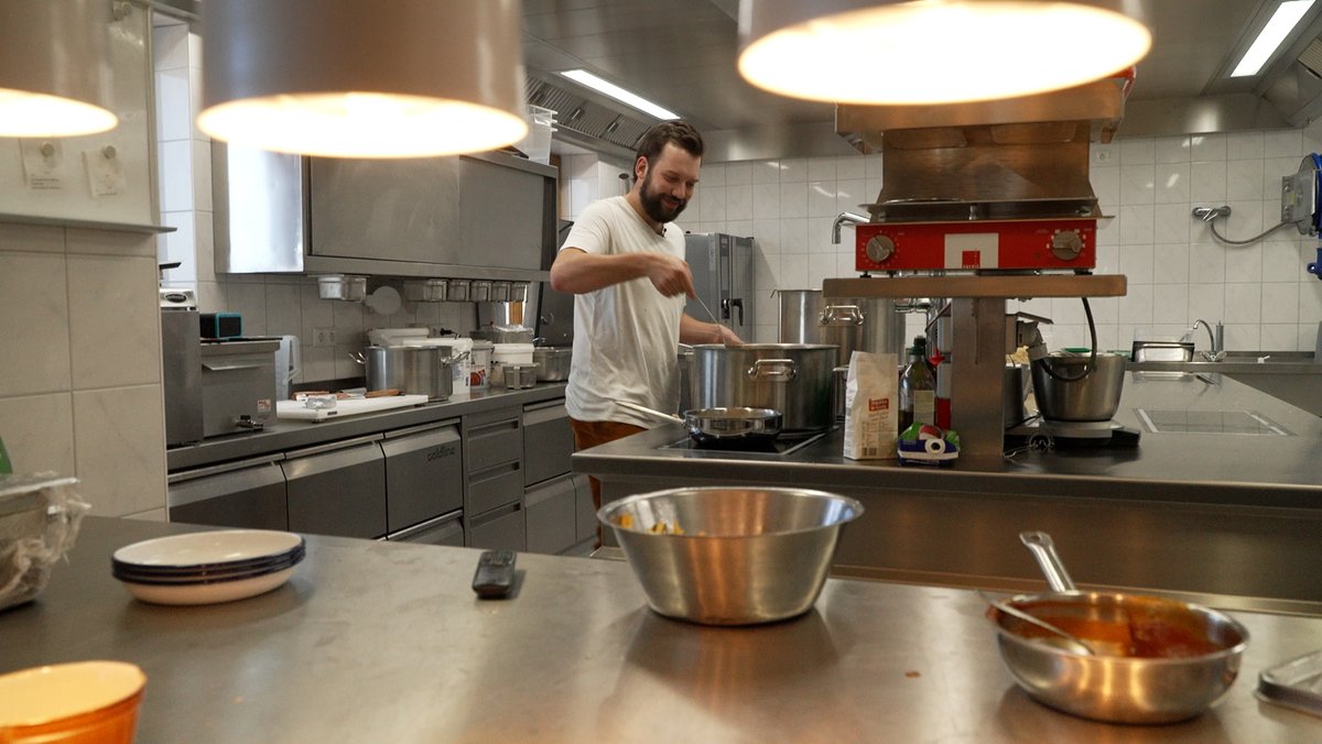 Philipp Schmöller steht in der Küche des Berggasthofs am Dreisessel und kocht.