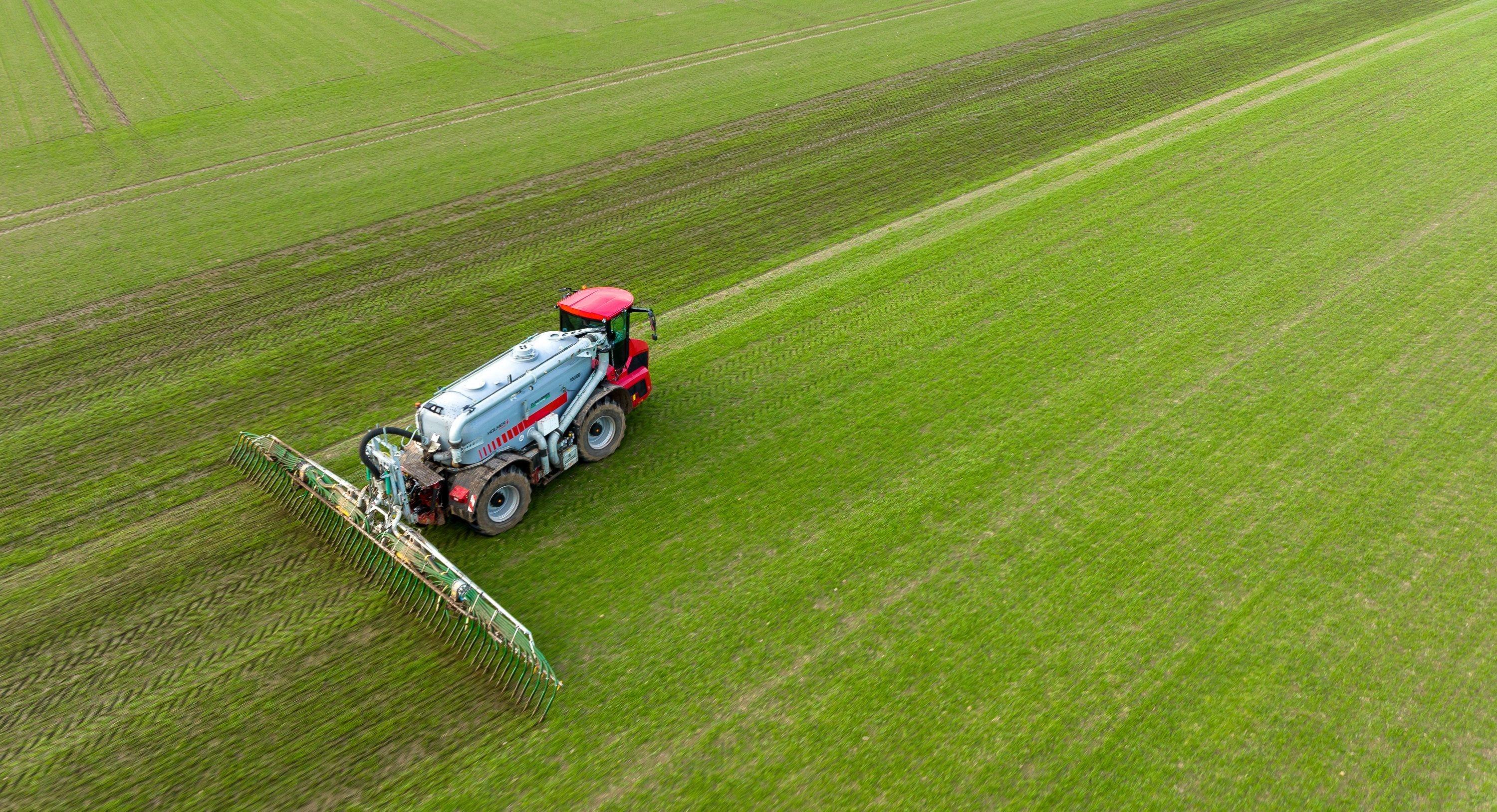 Ein Landwirt bringt Gülle auf einem Feld aus (Archivaufnahme mit einer Drohne)