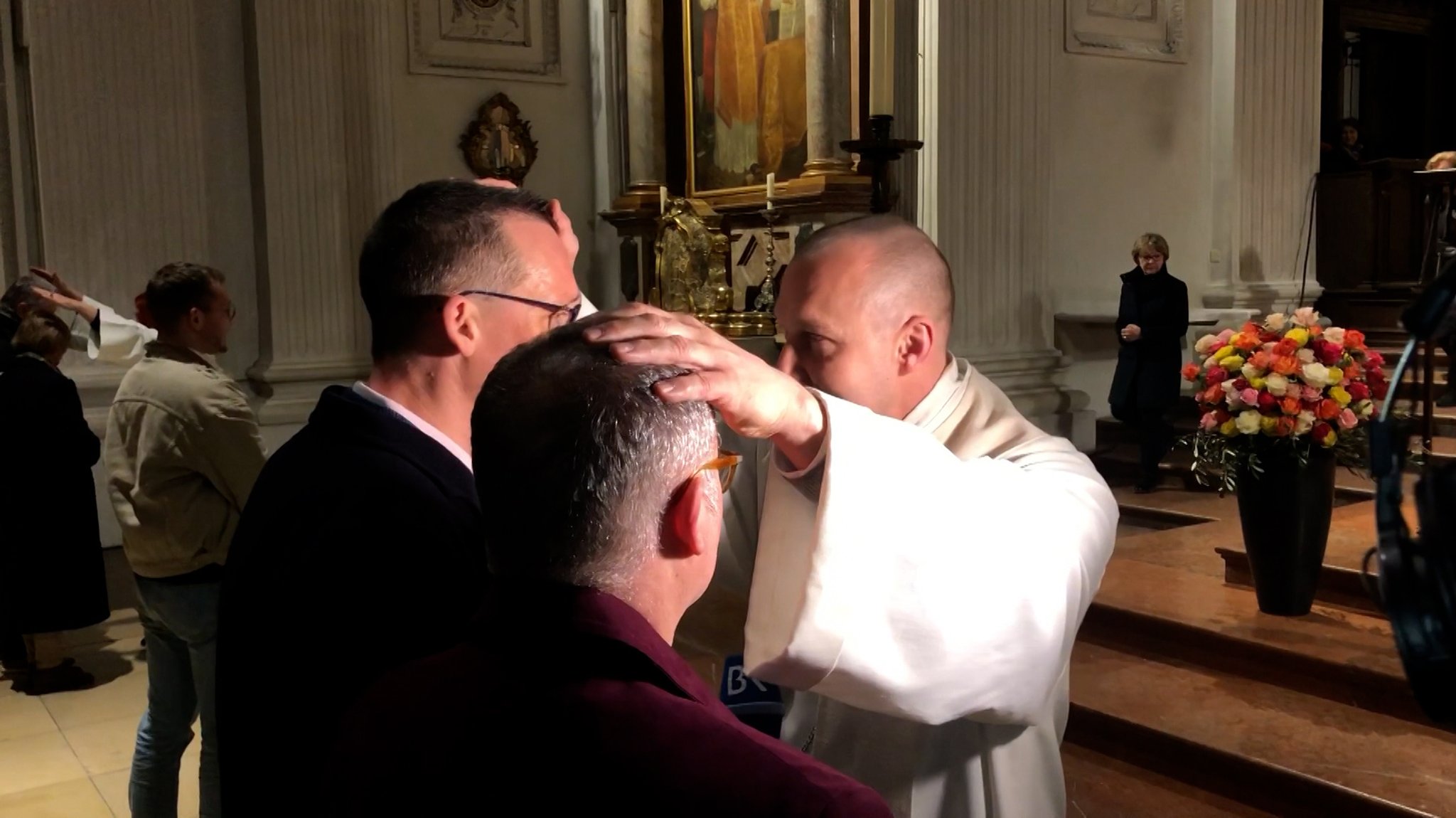 Zwei Männer werden in einer Kirche gesegnet.