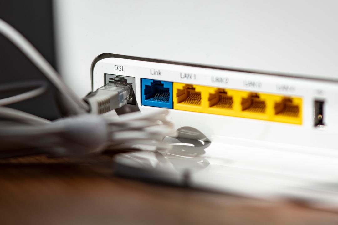 Ein LAN-Kabel steckt im DSL-Steckplatz eines WLAN-Routers.