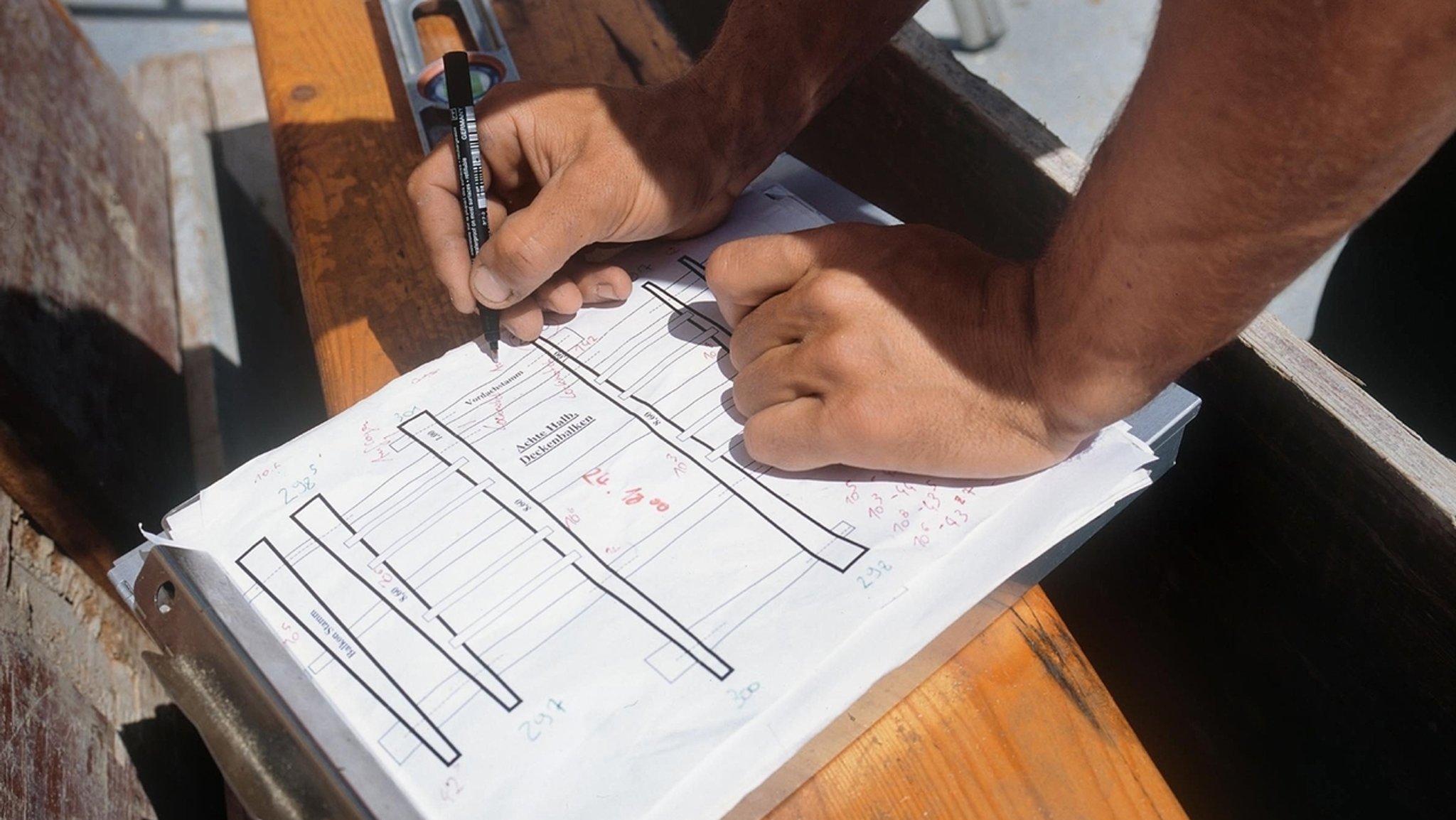 Handwerker mit Bauplan beim Bau eines Holzhauses