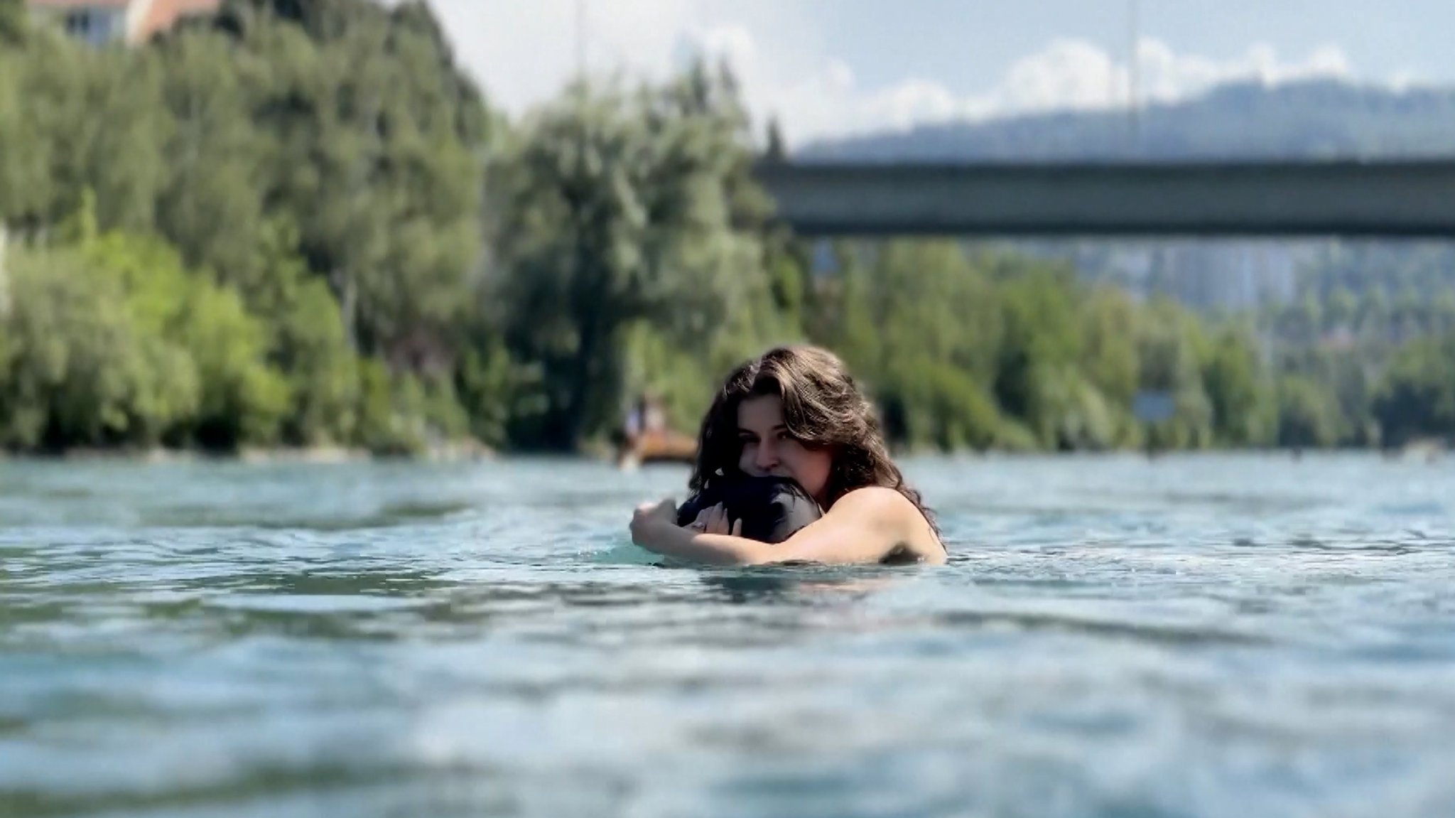 (Symbolbild) Eine junge Frau lässt sich in einem Fluss treiben. 