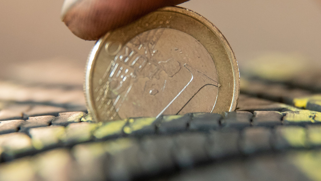 Eine 1 Euro-Münze steckt im Reifenprofil