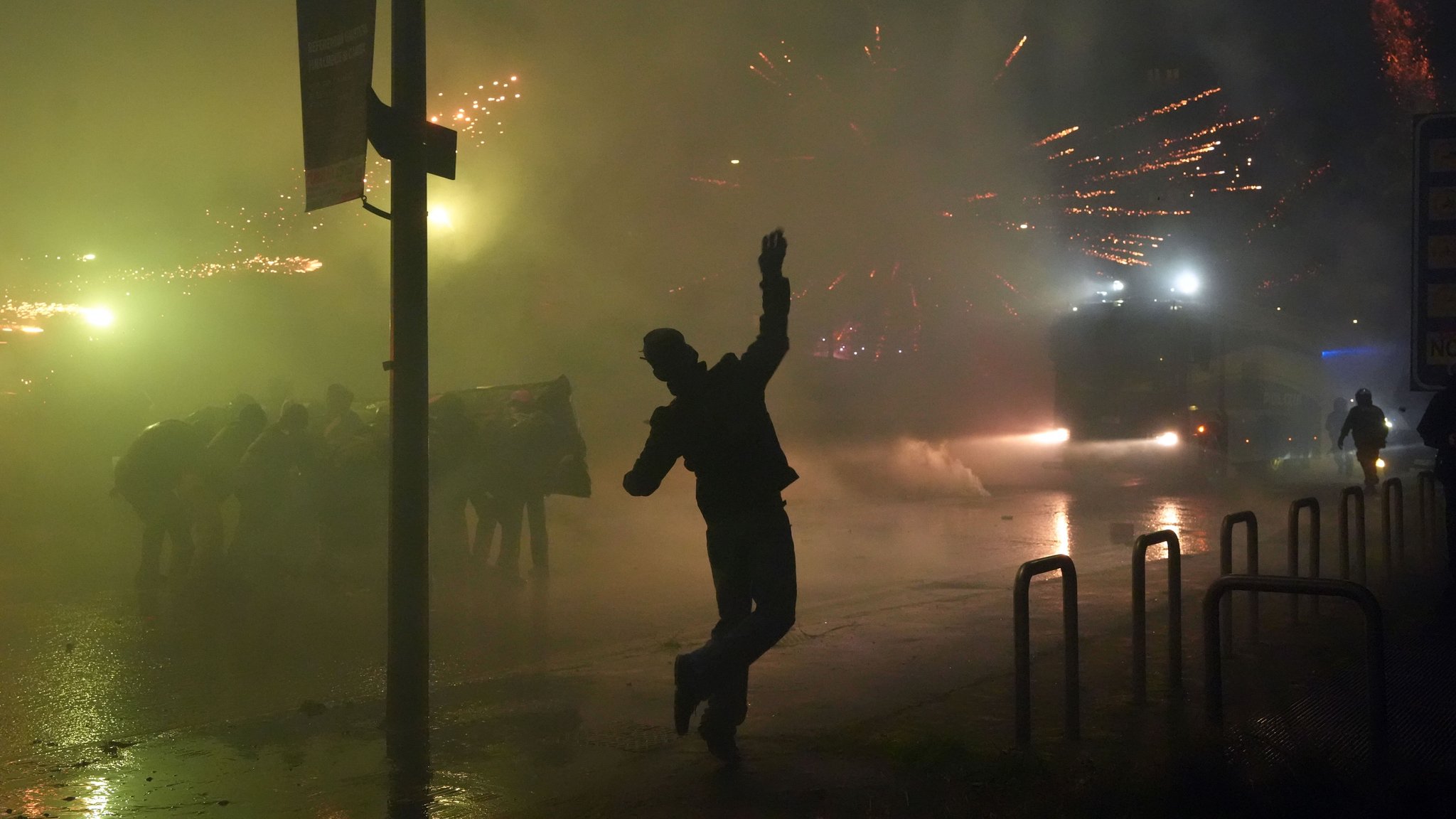 Ein junger Demonstrant wirft bei den Ausschreitungen in Mailand einen Feuerwerkskörper in Richtung der Sicherheitskräfte.