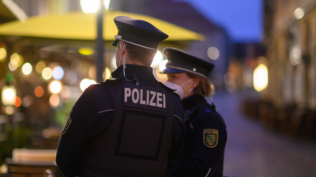 Polizisten patrouillieren durch eine menschenleere Straße (Symbolbild)