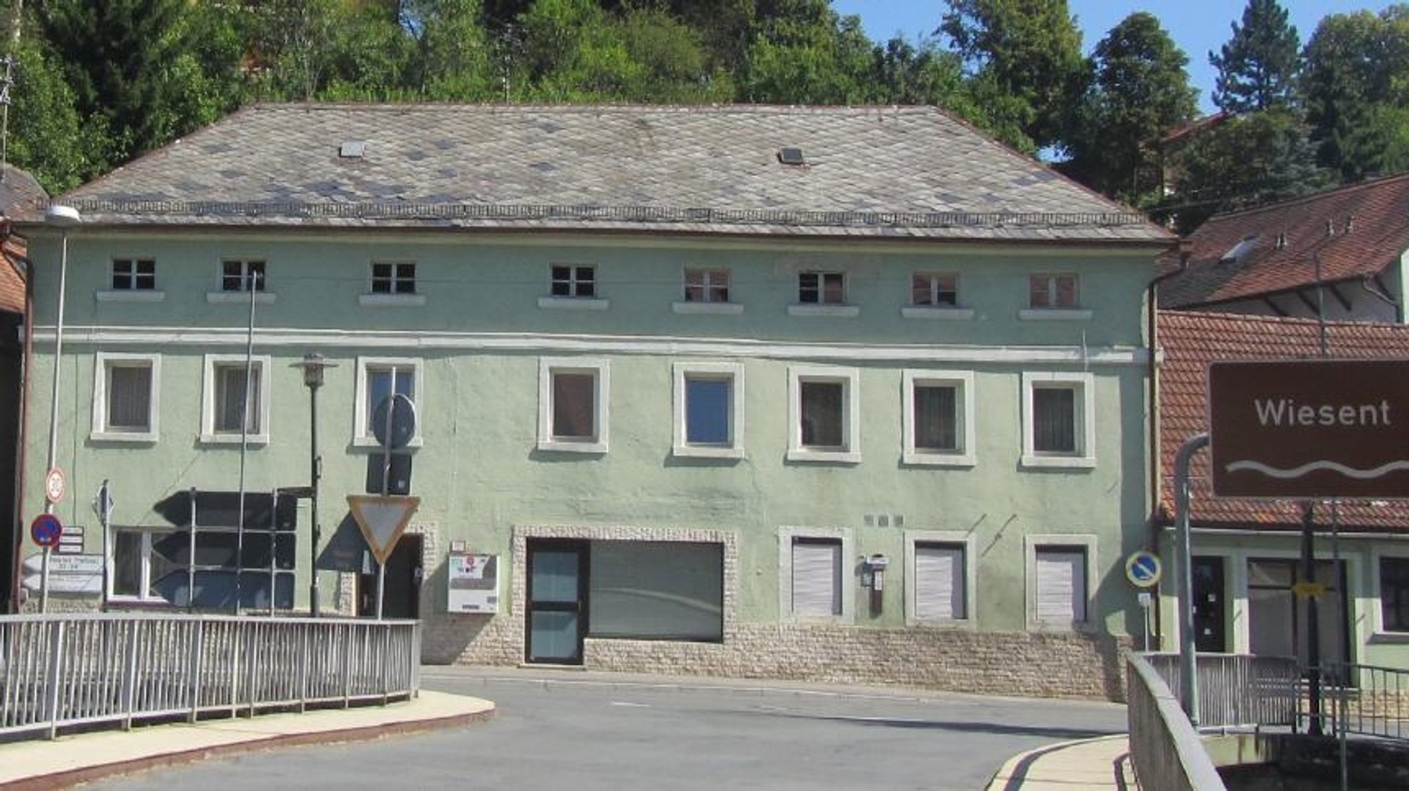 Ein altes hellgrün gestrichenes Haus an der Wiesent in Waischenfeld. 