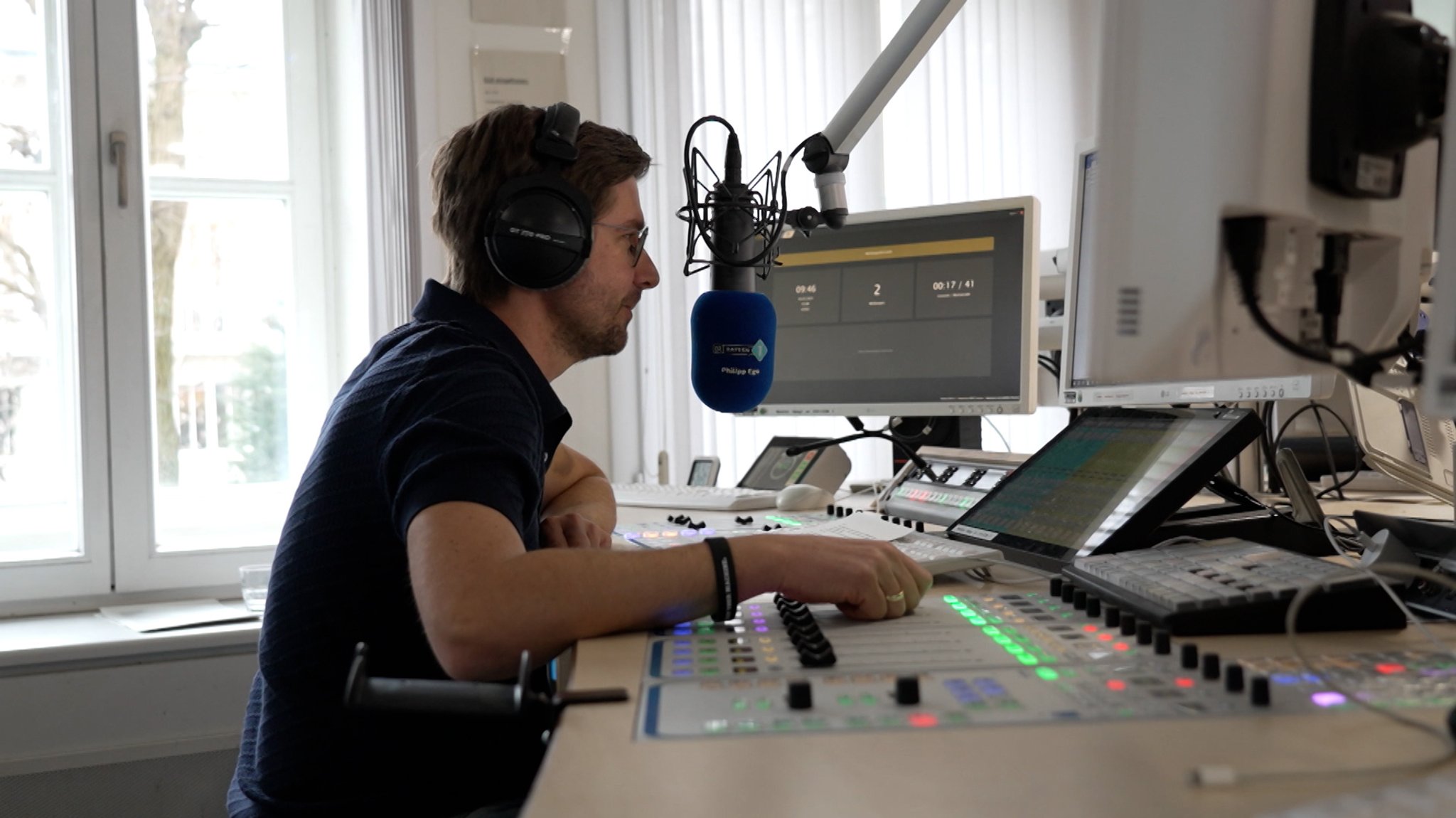 Ein Moderator bedient ein Mischpult in einem Hörfunk-Studio.