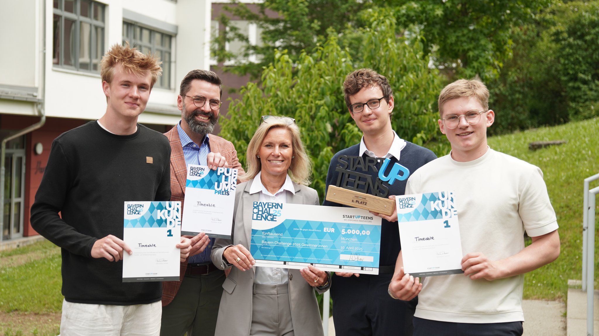 Ersttester Noah Kolbert und die Leitung des Gymnasiums Marktbreit mit Timeable-Erfindern Valentin Hemm und Ben Tovote (links nach rechts).