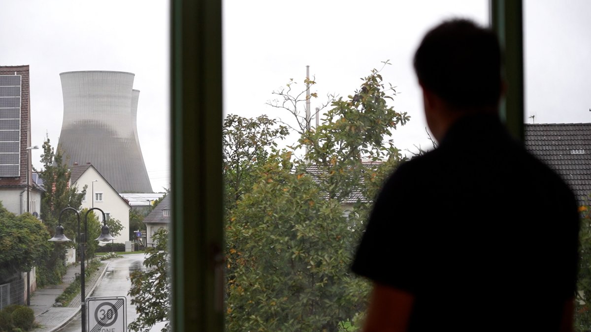 Gundremmingens Bürgermeister Tobias Bühler schaut aus seinem Bürofenster im Rathaus auf die Kühltürme. | Bild: BR/Peter Allgaier Gundremmingens Bürgermeister Tobias Bühler schaut aus seinem Bürofenster im Rathaus auf die Kühltürme.