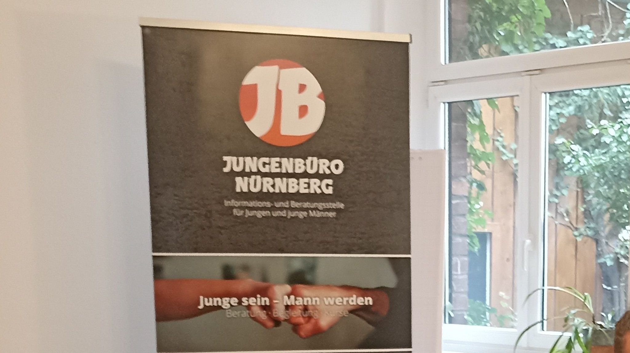 Das Schild "Jugendbüro Nürnberg" vor einem Fenster. 