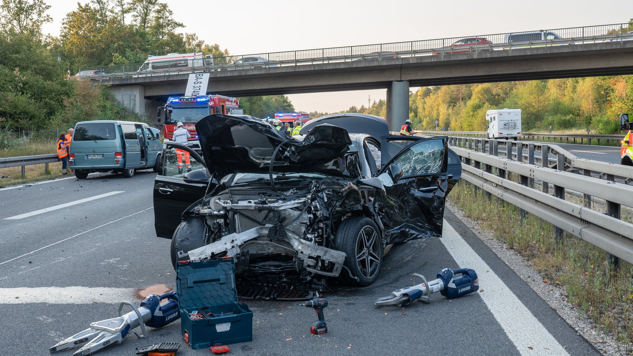 Blick auf ein Autowrack und eine Autobahnbrücke.