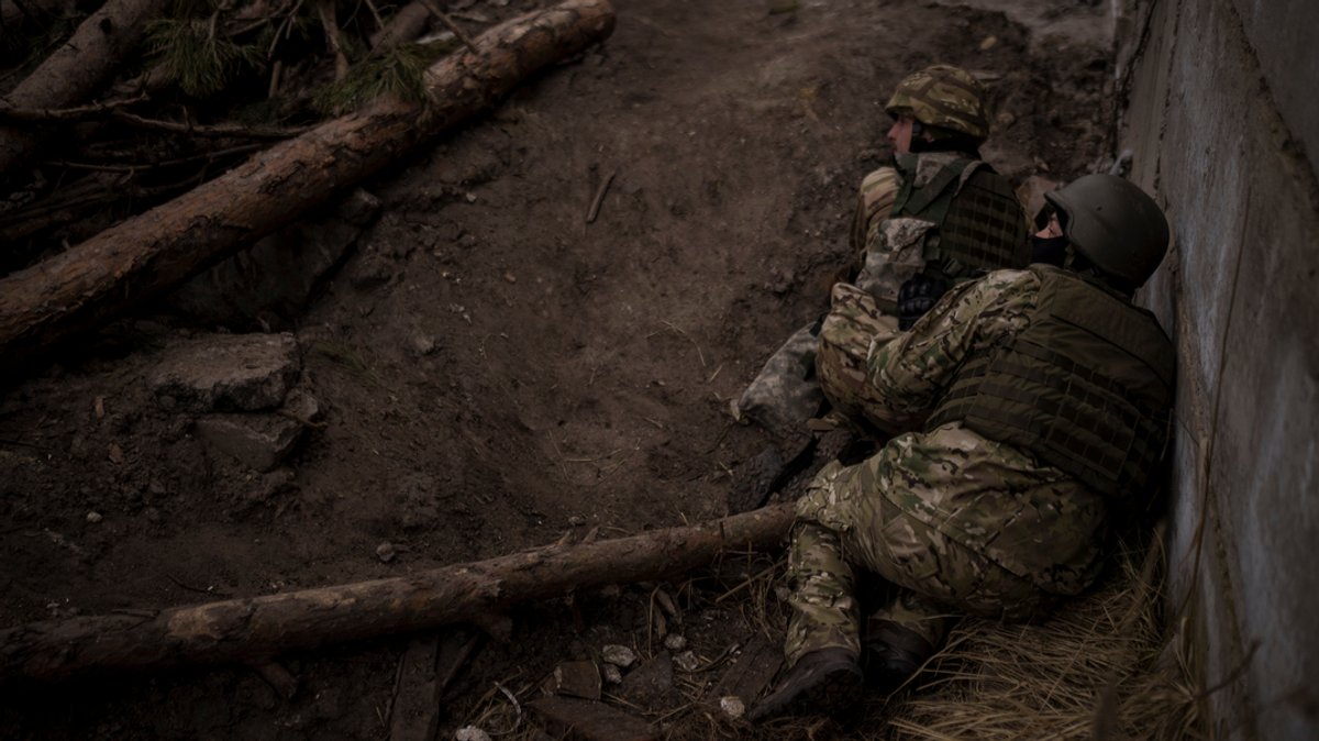 Ukrainische Soldaten gehen in Irpin nordwestlich von Kiew vor Artilleriebeschuss in Deckung.
