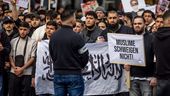 Teilnehmer einer Islamisten-Demo halten ein Plakat mit der Aufschrift "Muslime schweigen nicht" in die Höhe. | Bild:dpa-Bildfunk/Axel Heimken
