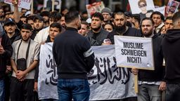 Teilnehmer einer Islamisten-Demo halten ein Plakat mit der Aufschrift "Muslime schweigen nicht" in die Höhe. | Bild:dpa-Bildfunk/Axel Heimken