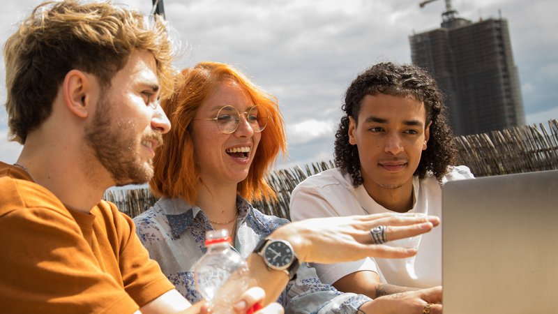 Eine Gruppe von jungen Leuten sitzt auf einer Dachterrasse in Berlin vor einem Laptop | Bild: picture alliance / dpa-tmn | Christin Klose Eine Gruppe von jungen Leuten sitzt auf einer Dachterrasse in Berlin vor einem Laptop