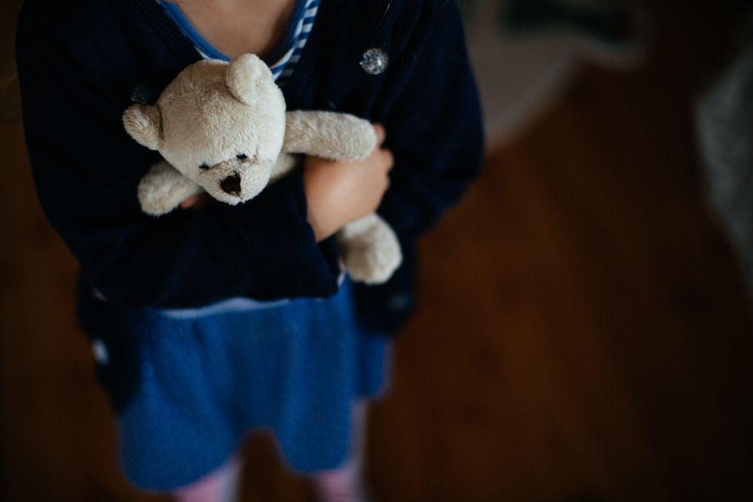 Symbolbild: Kind umklammert seinen Teddybären
