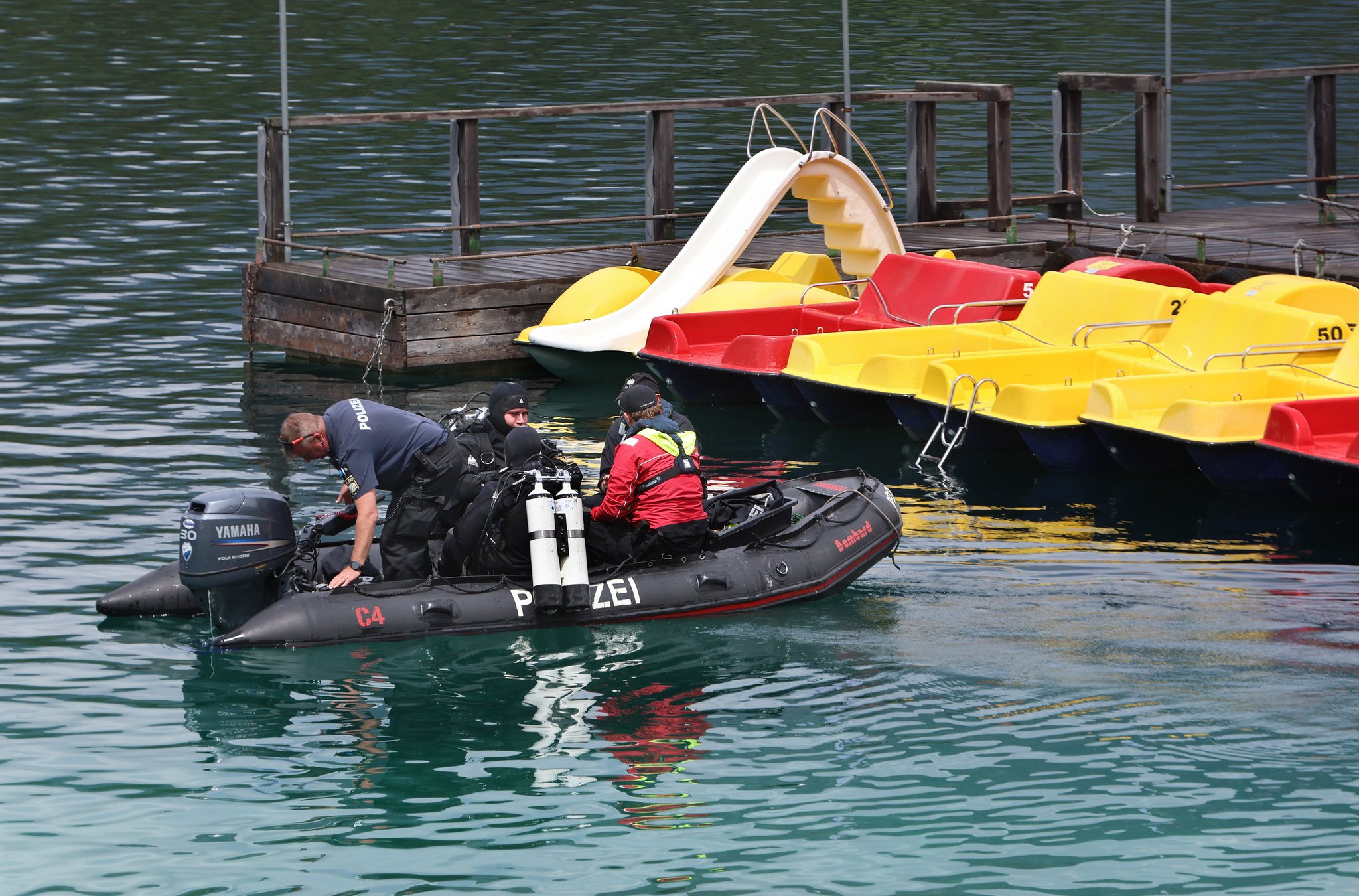 06.07.2025, Bayern, Grainau: Polizeitaucher fahren in einem Schlauchboot, vor den Tretbooten eines geschlossenen Bootsverleihs, hinaus auf den Eibsee. Ein 33 Jahre alter Mann und sein sechsjähriger Sohn sind nach Polizeiangaben in dem See untergegangen. Sie waren auf einem Tretboot unterwegs. Foto: Karl-Josef Hildenbrand/dpa +++ dpa-Bildfunk +++ | Bild: dpa-Bildfunk/Karl-Josef Hildenbrand 06.07.2025, Bayern, Grainau: Polizeitaucher fahren in einem Schlauchboot, vor den Tretbooten eines geschlossenen Bootsverleihs, hinaus auf den Eibsee. Ein 33 Jahre alter Mann und sein sechsjähriger Sohn sind nach Polizeiangaben in dem See untergegangen. Sie waren auf einem Tretboot unterwegs. Foto: Karl-Josef Hildenbrand/dpa +++ dpa-Bildfunk +++