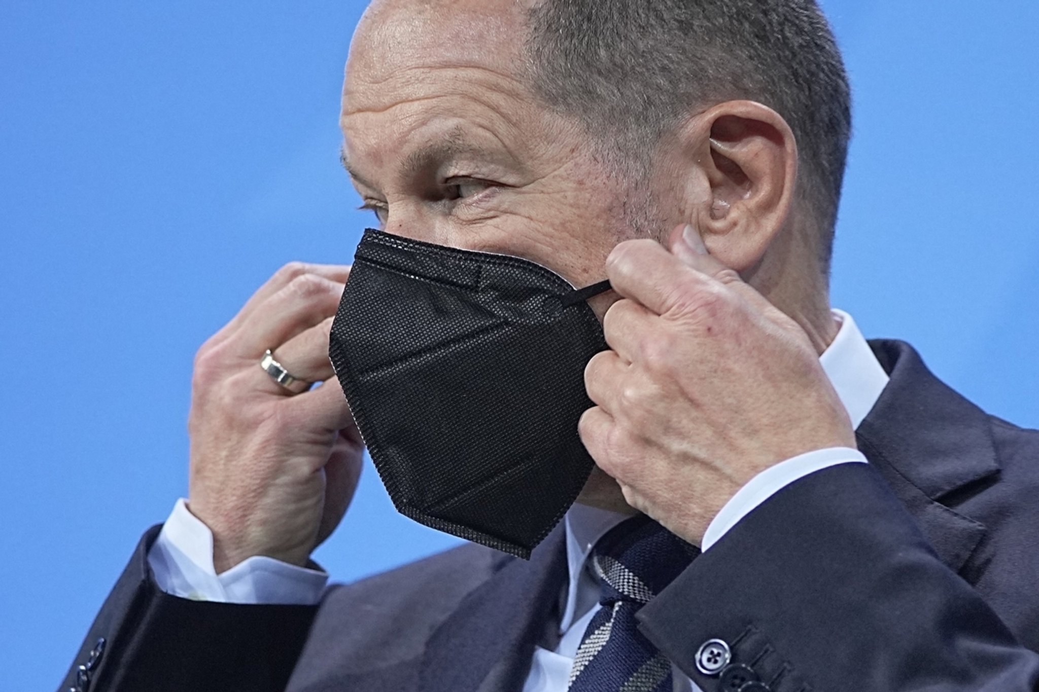 09.12.2021, Berlin: Bundeskanzler Olaf Scholz (SPD), setzt nach einer Pressekonferenz nach den Beratungen der Bundesregierung mit den Ministerpräsidentinnen und Ministerpräsidenten der Länder seine Maske auf. Foto: Michael Kappeler/dpa-Pool/dpa +++ dpa-Bildfunk +++