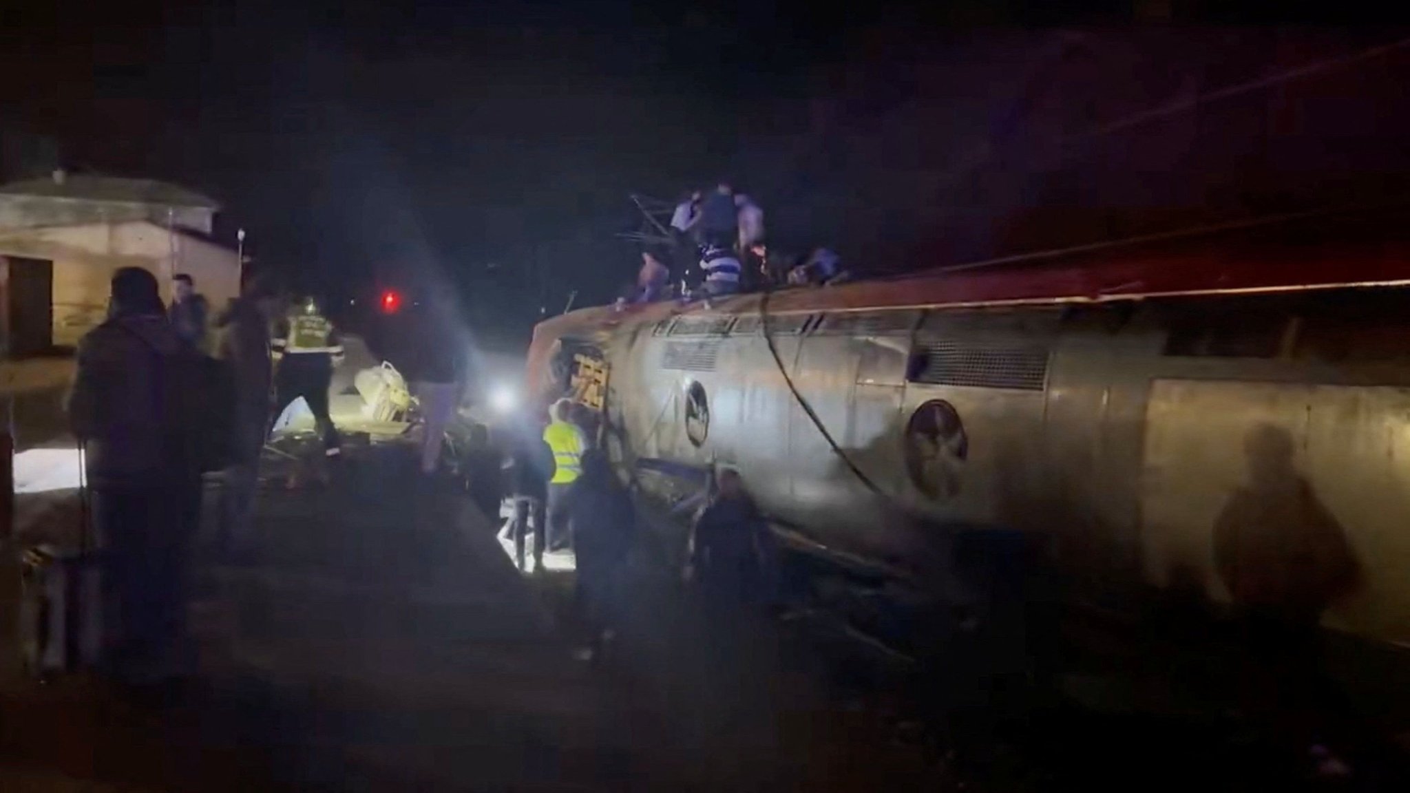 Verunglückter Hochgeschwindigkeitszug mit mehreren Ersthelfern | Bild: Reuters Verunglückter Hochgeschwindigkeitszug mit mehreren Ersthelfern