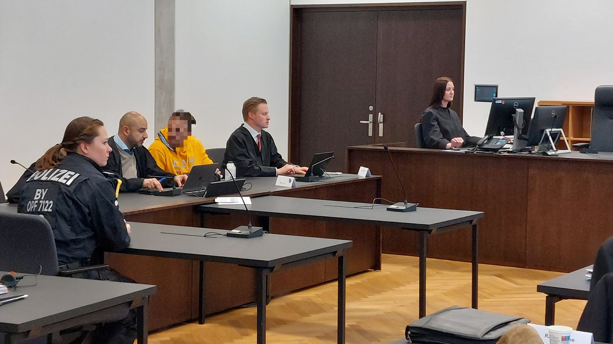 Angeklagter (verpixelt) mit Anwälten und Justizbeamten im Gerichtssaal