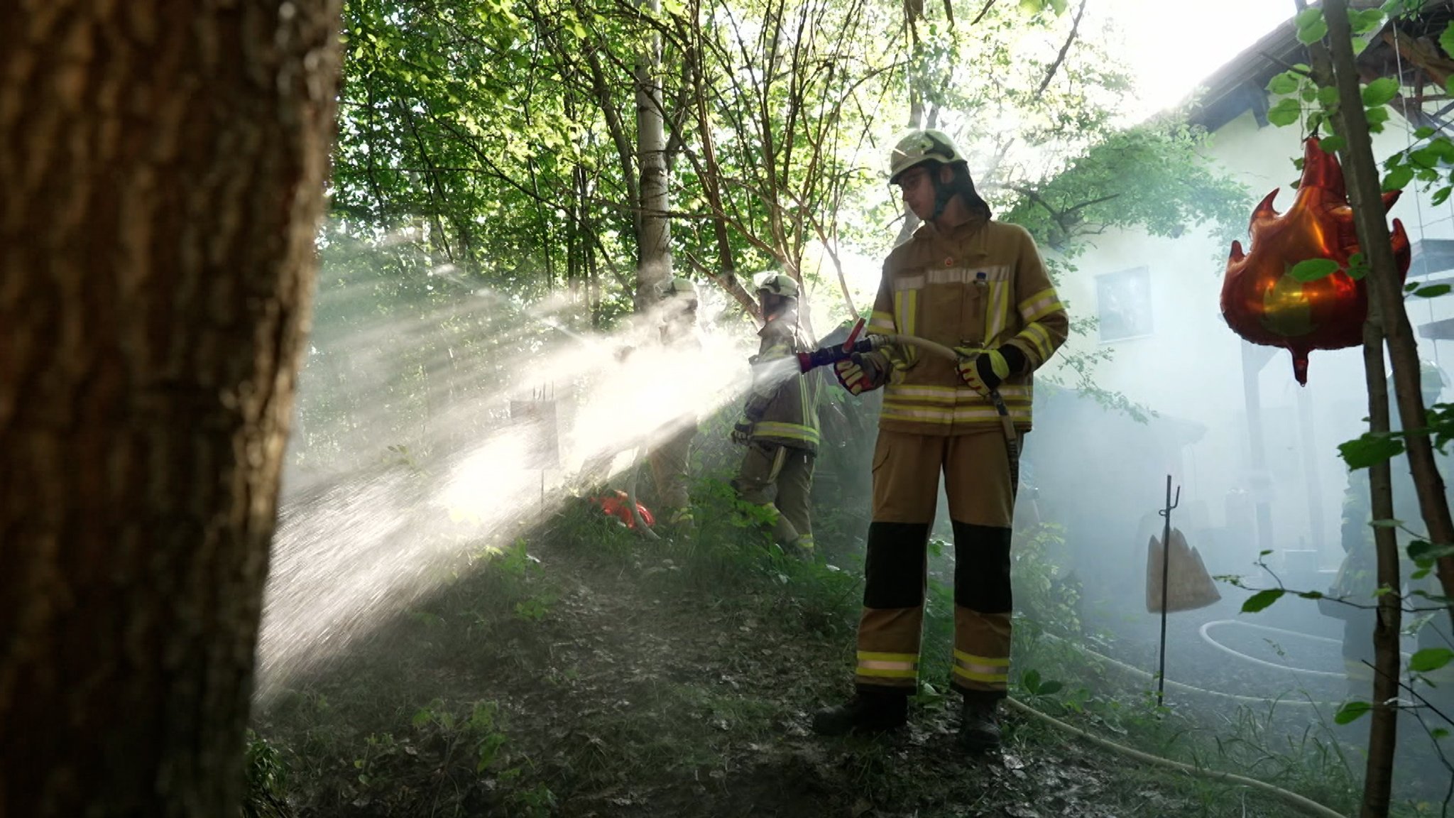 Feuerwehrmänner stehen in einem Wald und proben den Ernstfall eines Waldbrandes. | Bild: BR Feuerwehrmänner stehen in einem Wald und proben den Ernstfall eines Waldbrandes.