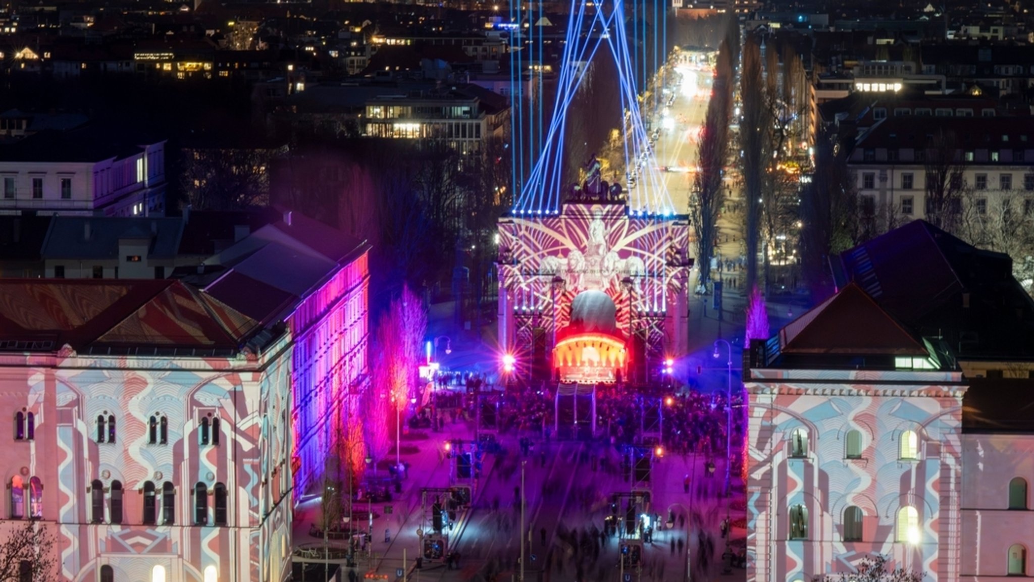 Das Siegestor in München ist bunt beleuchtet. 