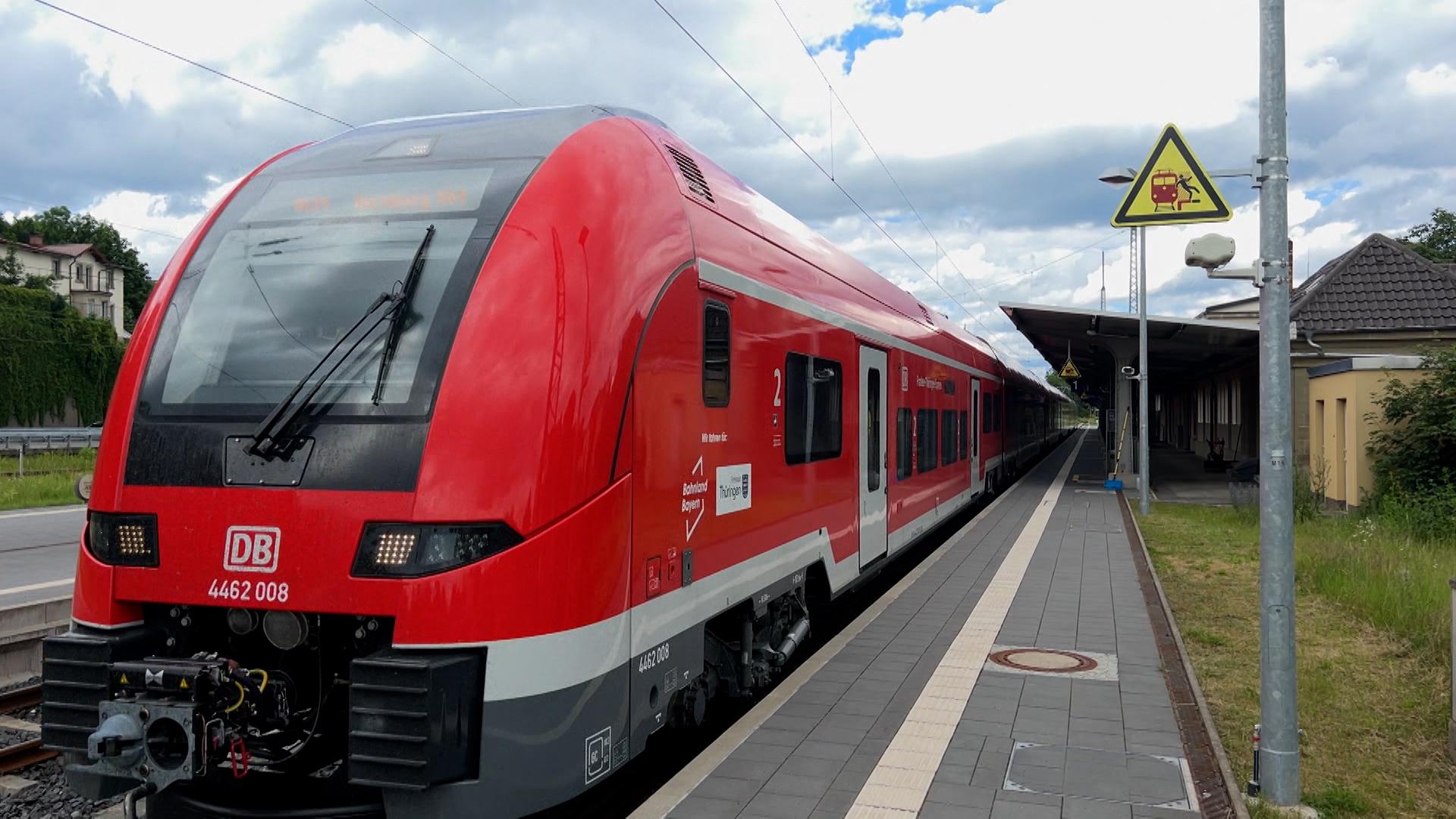 Ein roter Zug der DB an einem Bahnsteig.