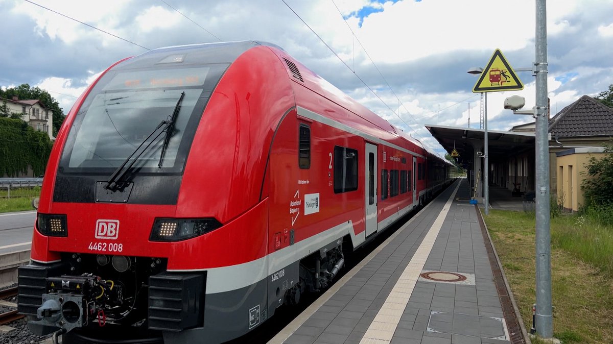 Ein roter Zug der DB an einem Bahnsteig.