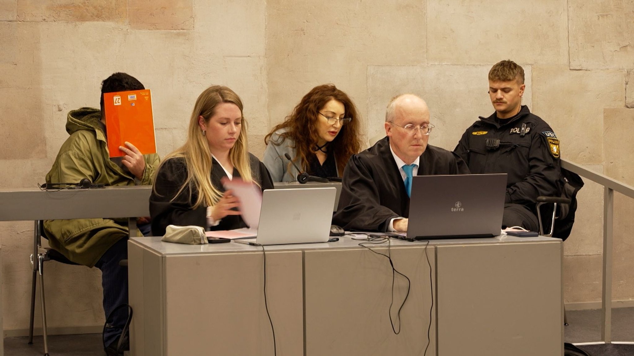 Der Mann nimmt neben seiner Dolmetscherin Platz. | Bild: Bayerischer Rundfunk Der Mann nimmt neben seiner Dolmetscherin Platz.