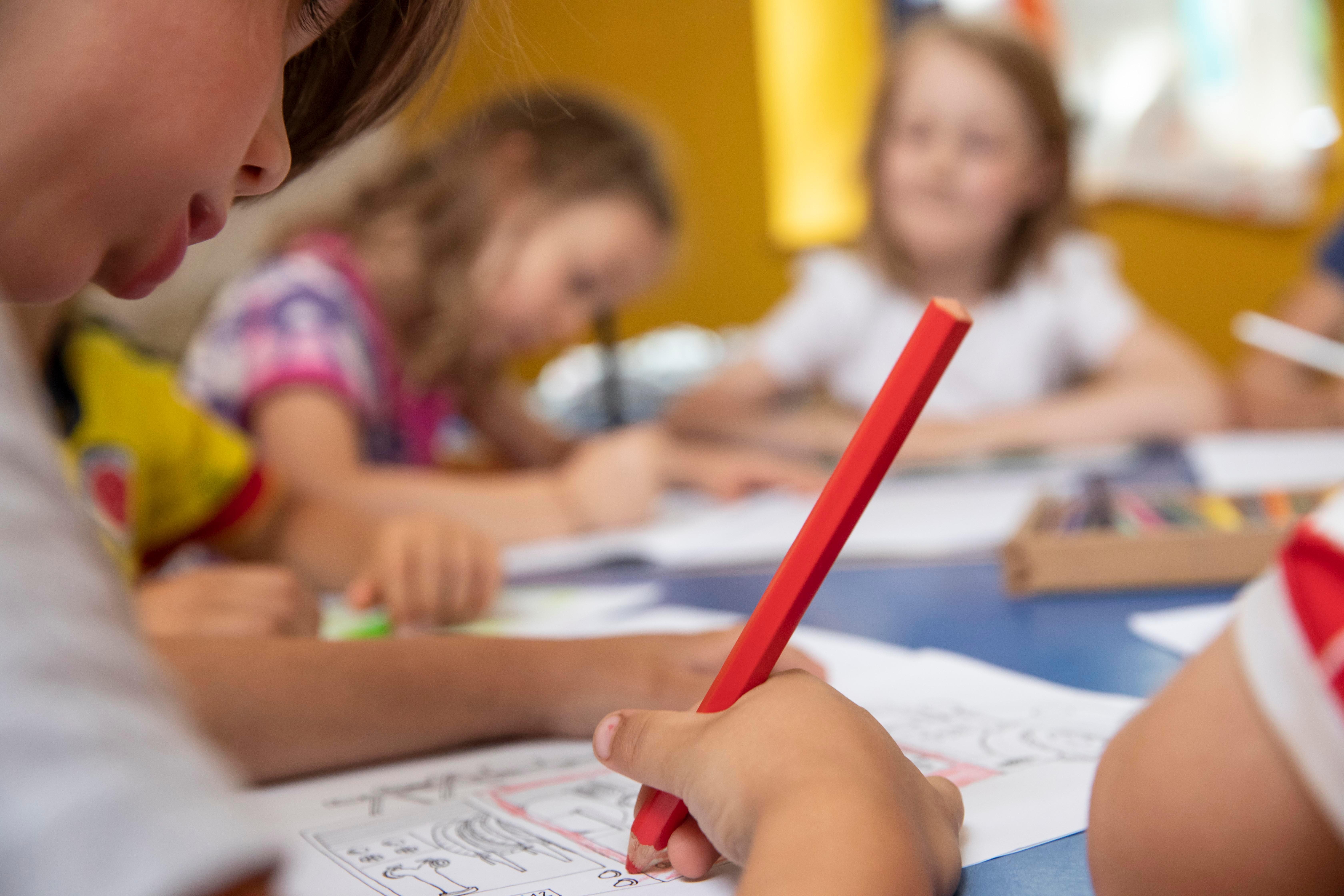 Kinder malen im Kindergarten mit Buntstiften