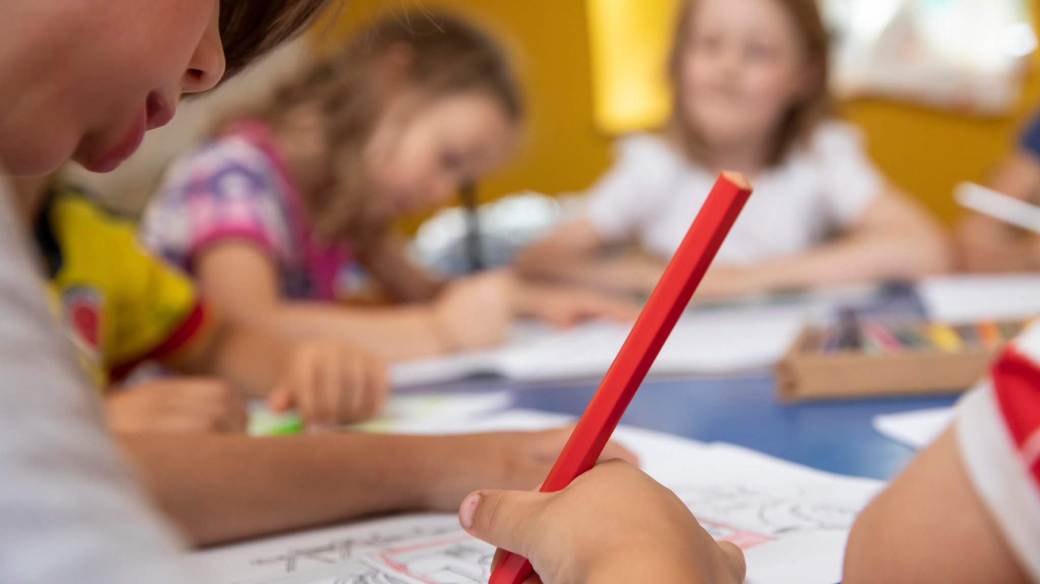 Kinder malen im Kindergarten mit Buntstiften