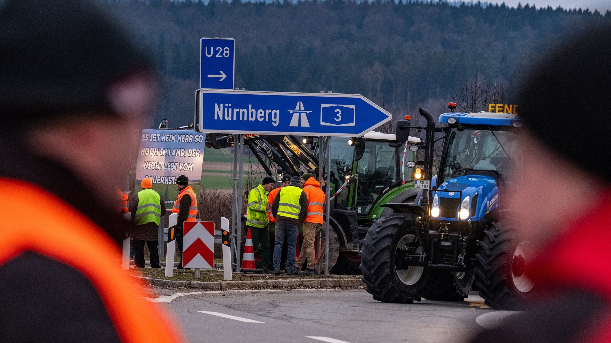 08.01.2024, Bayern, Kirchroth: Traktoren von protestierenden Landwirten blockieren die Auffahrt zur Autobahn A3 Richtung Nürnberg. Als Reaktion auf die Sparpläne der Bundesregierung hat der Bauernverband zu einer Aktionswoche mit Kundgebungen und Sternfahrten ab dem 8. Januar aufgerufen. Sie soll am 15. Januar in einer Großdemonstration in Berlin gipfeln. Foto: Armin Weigel/dpa +++ dpa-Bildfunk +++