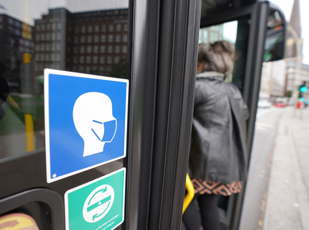 Ein Aufkleber an einem Linienbus weist auf die Maskenpflicht hin (Symbolbild).