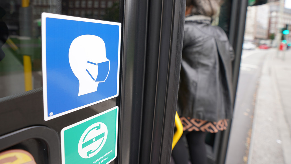Ein Aufkleber an einem Linienbus weist auf die Maskenpflicht hin (Symbolbild).