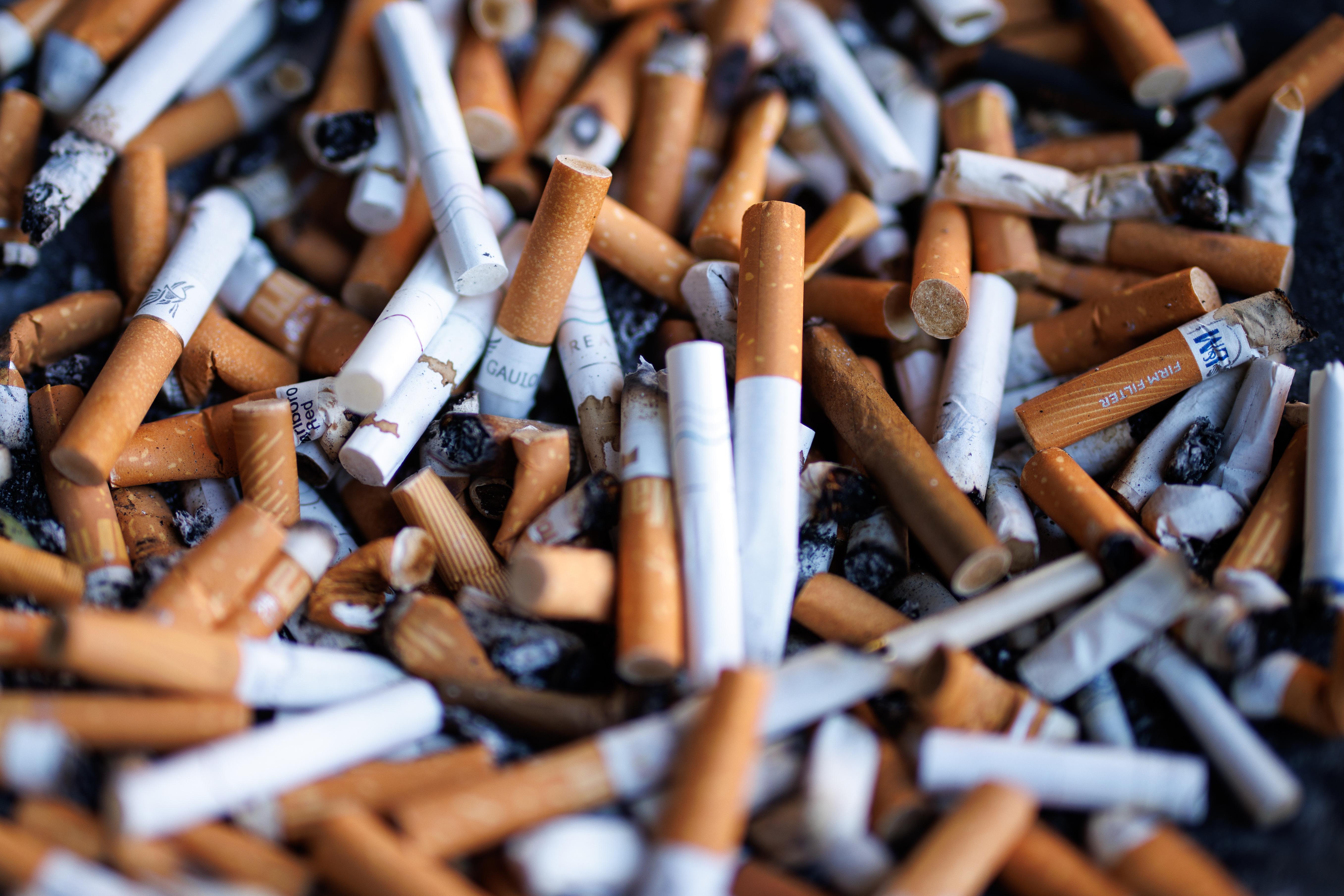 Zahlreiche Zigarettenstummel liegen in einem Aschenbecher an einem öffentlichen Gebäude in München.  