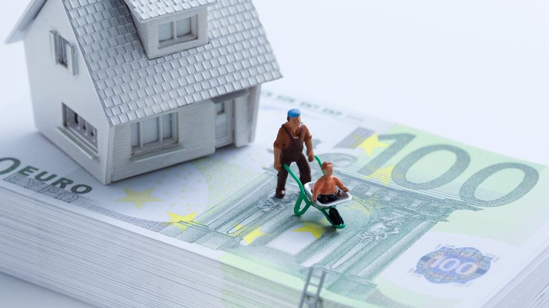 Hausmodell und Figuren auf Stapel Euroscheine | Bild: MEV/Karl Holzhauser Hausmodell und Figuren auf Stapel Euroscheine