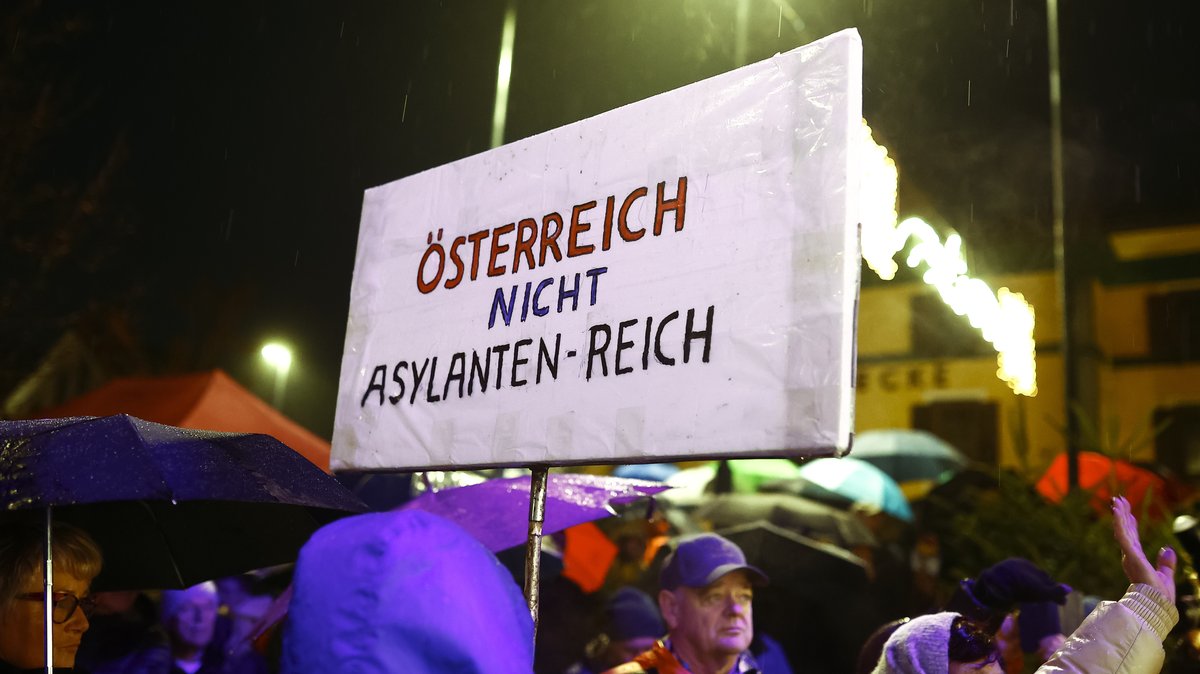 Ein Demonstrant hält bei einer Kundgebung der FPÖ gegen eine geplante Asylbewerberunterkunft ein Schild auf dem steht: "Österreich nicht Asylanten-Reich".