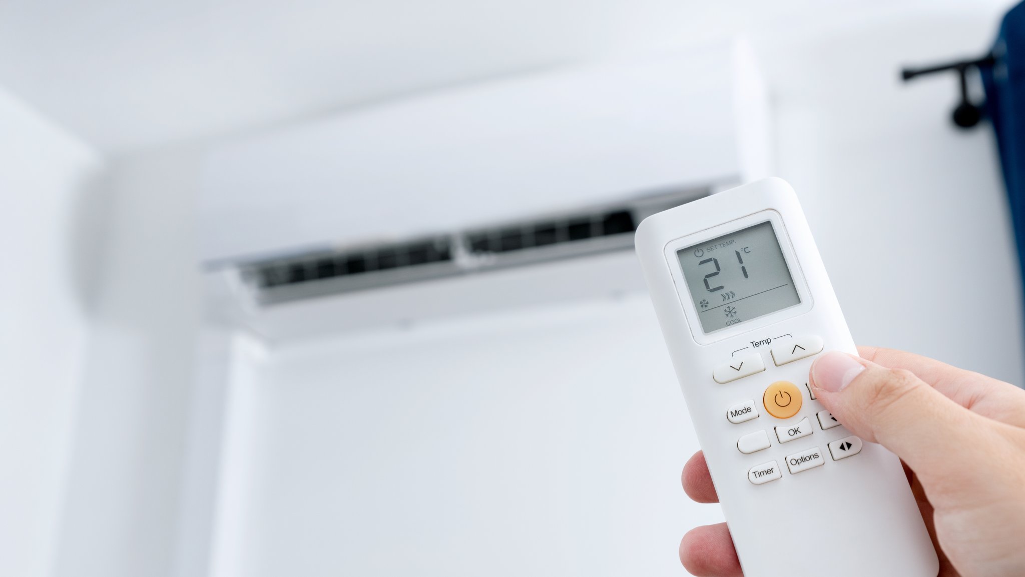 Eine Person stellt eine Klimaanlage ein. (Symbolbild)
