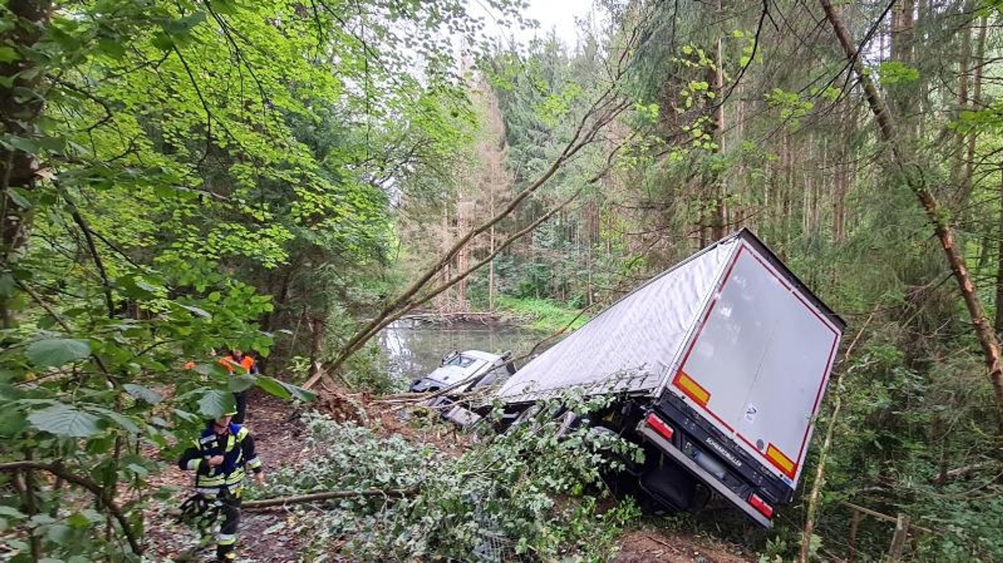 Sattelzug rutscht Böschung hinunter und landet im Weiher