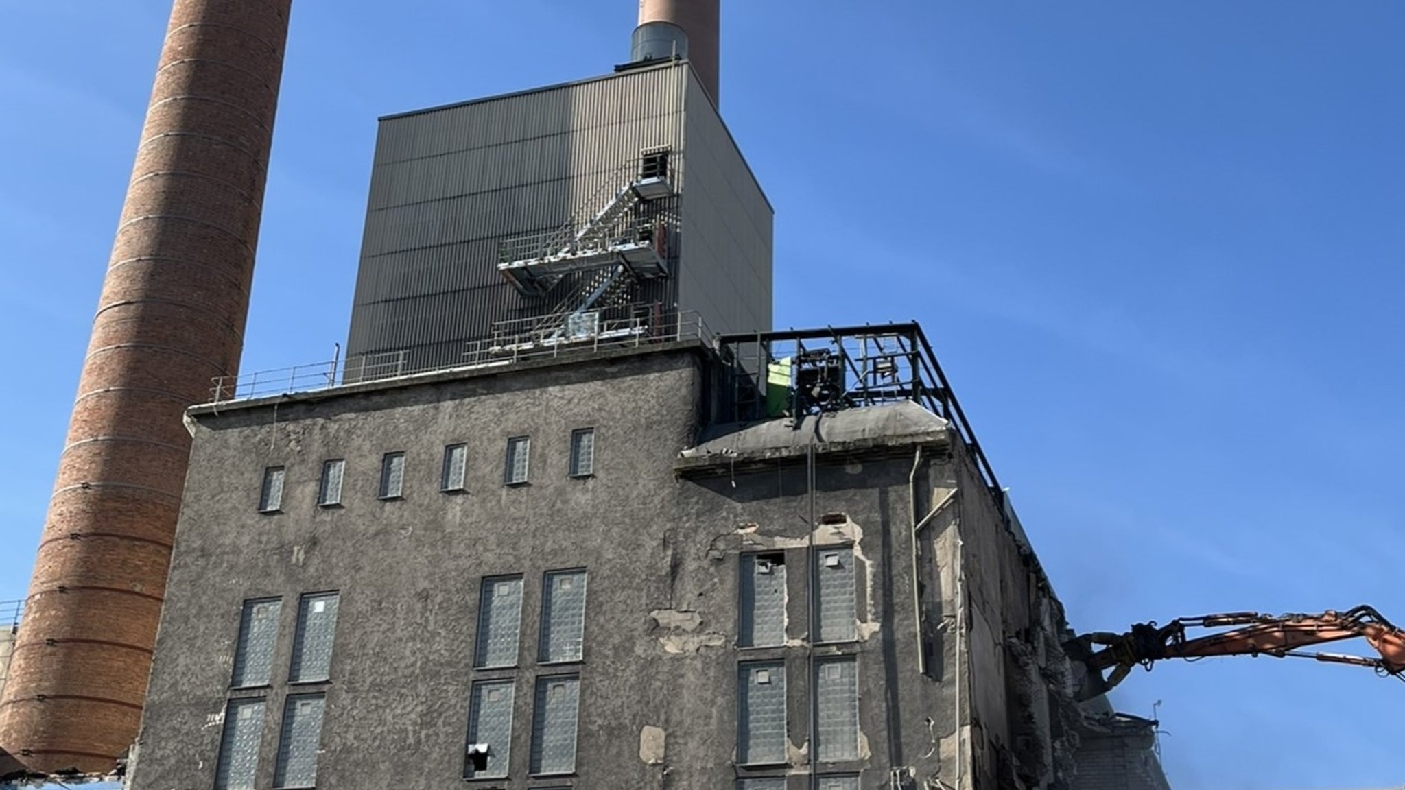 Ein altes Industriegelände mit kaputten Fenstern und zwei großen und hohen Schornsteinen. 