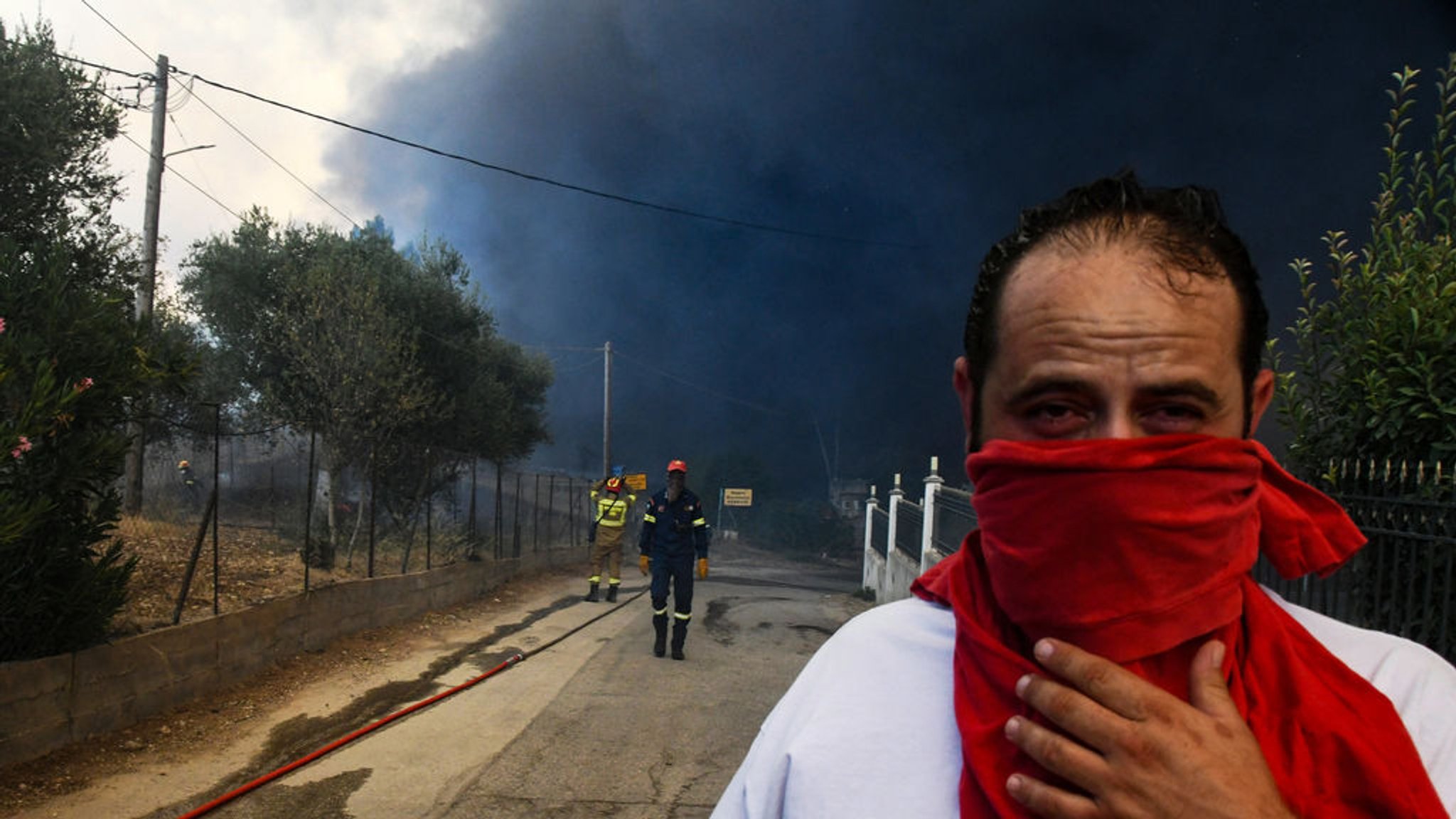 12.08.2025, Griechenland, Moiraiika: Schwarzer Rauch bedeckt den Himmel während eines Waldbrandes im Dorf Moiraiika in der Nähe der Stadt Patras, Westgriechenland. 