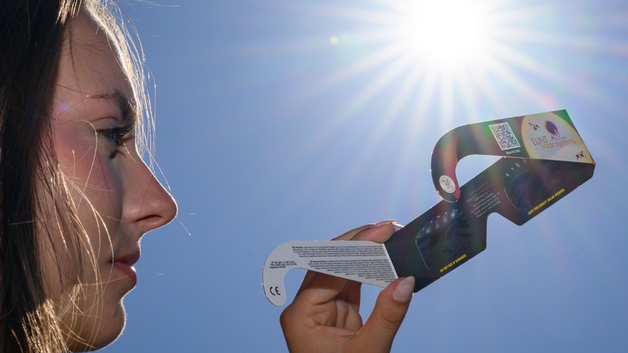 (Symbolbild) Eine junge Frau hält eine Schutzbrille zum Beobachten einer Sonnenfinsternis in der Hand. | Bild: dpa-Bildfunk/Patrick Pleul (Symbolbild) Eine junge Frau hält eine Schutzbrille zum Beobachten einer Sonnenfinsternis in der Hand.