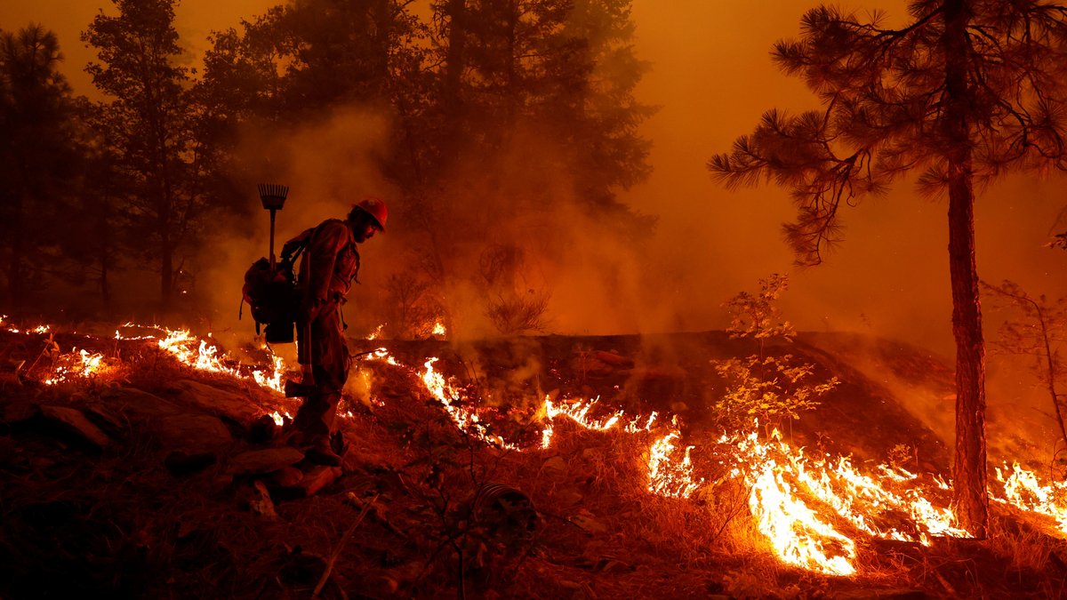 Feuerwehrmann bekämpft "Dixie Fire" im Wald bei Westwood, Kalifornien, USA