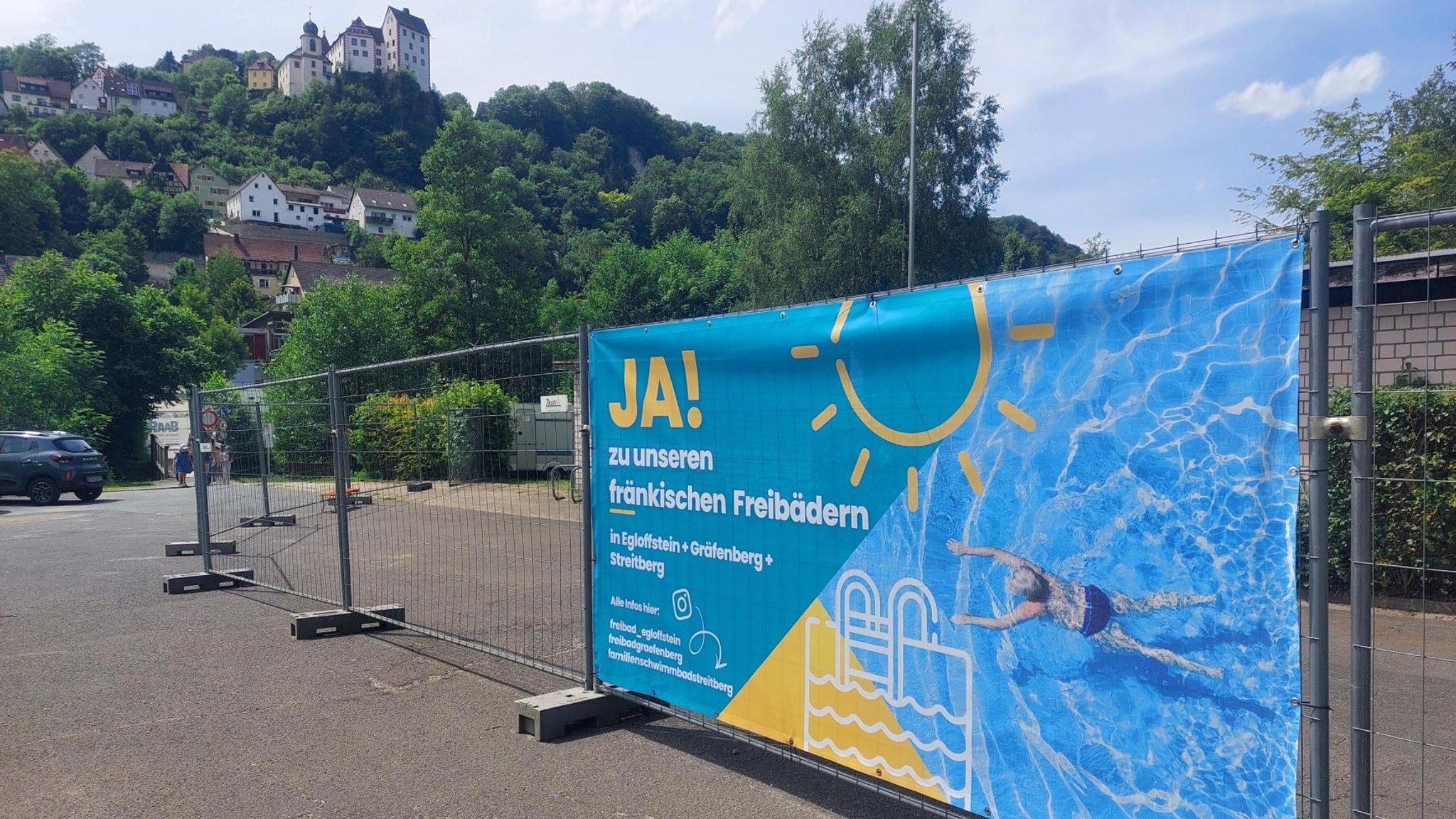 Ein Bauzaun steht vor dem Schwimmbad in Egloffstein. Dort steht geschrieben "Ja! zu fränkischen Freibädern".