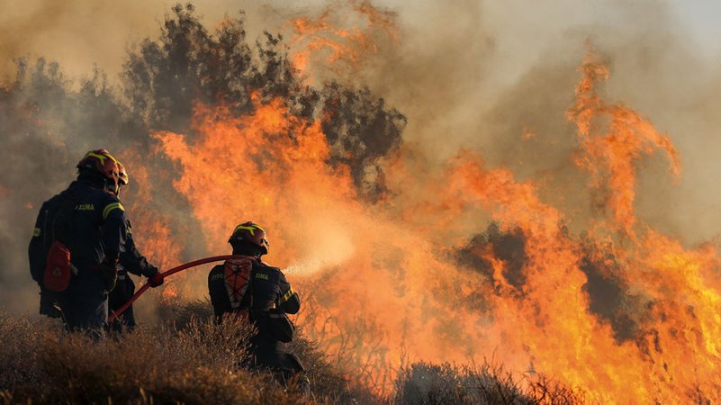 Feuerwehrleute bekämpfen die Flammen, die in der Nähe von Ierapetra auf der Insel Kreta weiter Wälder und Ackerland verbrennen. | Bild: dpa-Bildfunk/Stefanos Repanis Feuerwehrleute bekämpfen die Flammen, die in der Nähe von Ierapetra auf der Insel Kreta weiter Wälder und Ackerland verbrennen.