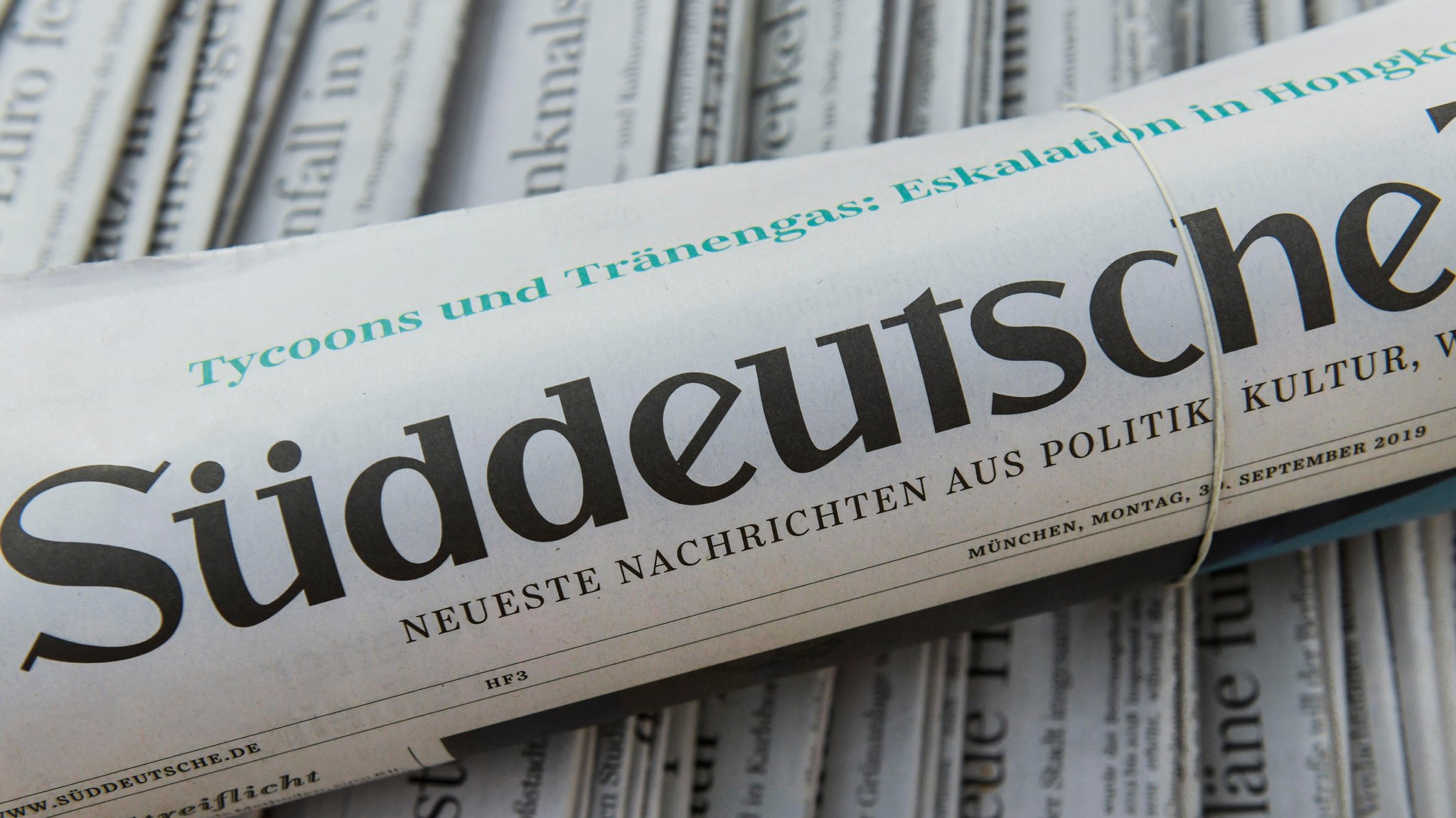 Eine Ausgabe der SZ liegt zusammengerollt auf Zeitungen | Bild: picture alliance / imageBROKER | Schoening Eine Ausgabe der SZ liegt zusammengerollt auf Zeitungen
