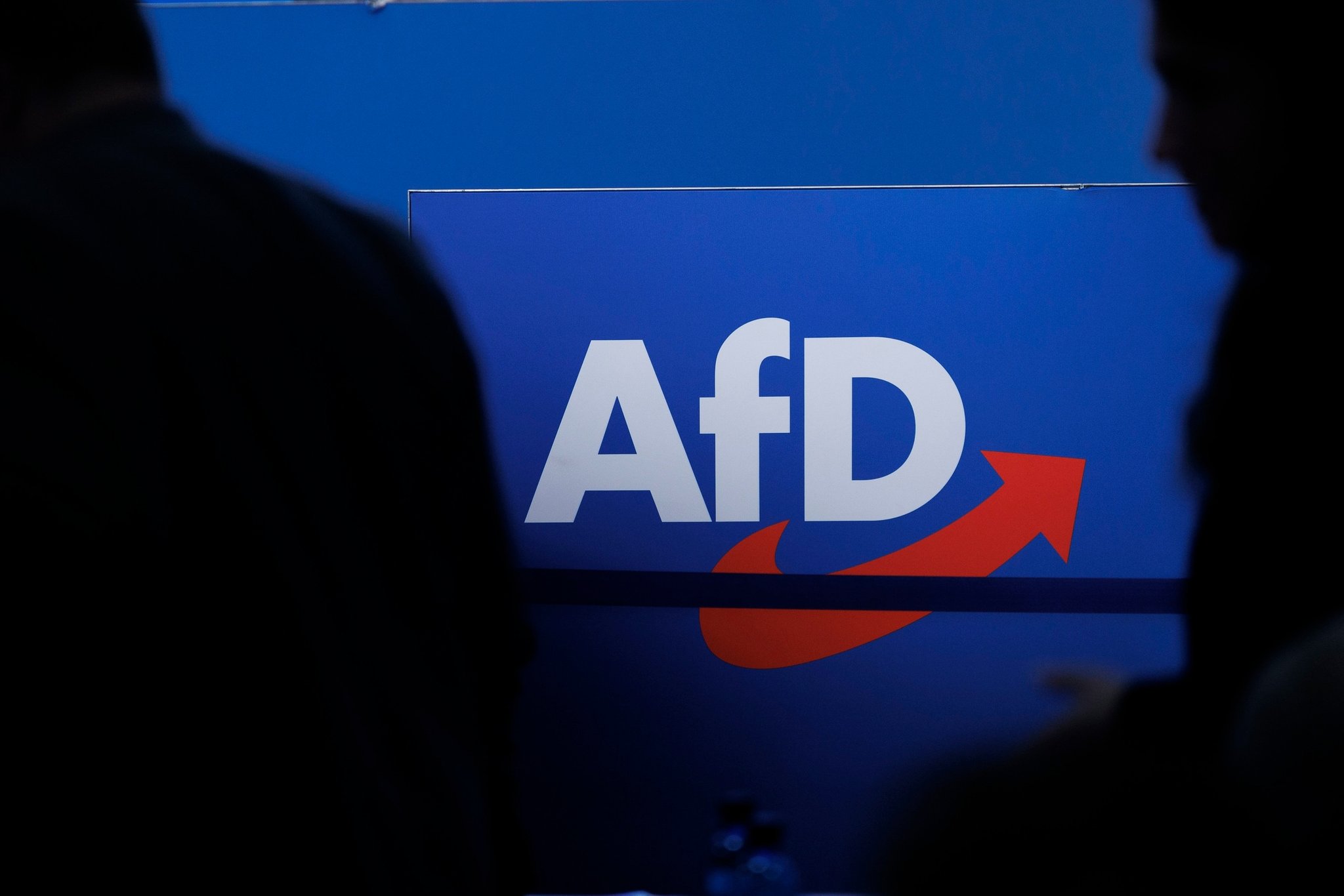 ARCHIV - 28.07.2023, Sachsen-Anhalt, Magdeburg: Delegierte gehen vor dem Parteilogo bei dem AfD-Bundesparteitag in Magdeburg. (zu dpa: «Abgeordnete mehrerer Fraktionen für AfD-Verbotsverfahren») Foto: Carsten Koall/dpa +++ dpa-Bildfunk +++