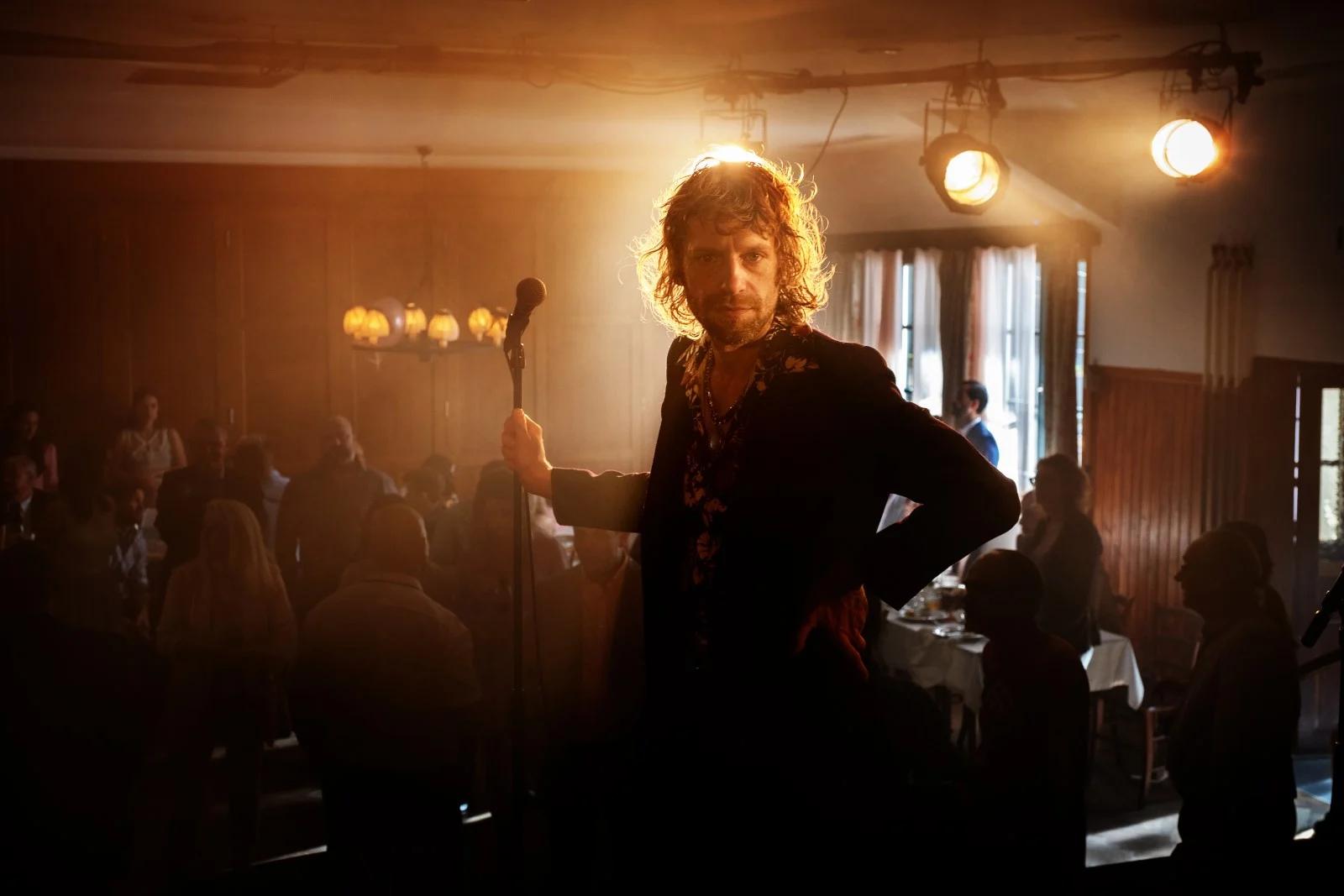 Man sieht den Sänger Voodoo Jürgens in einer Szene aus "Rickerl", er steht in einer Kneipe vor dem Mikrofon.